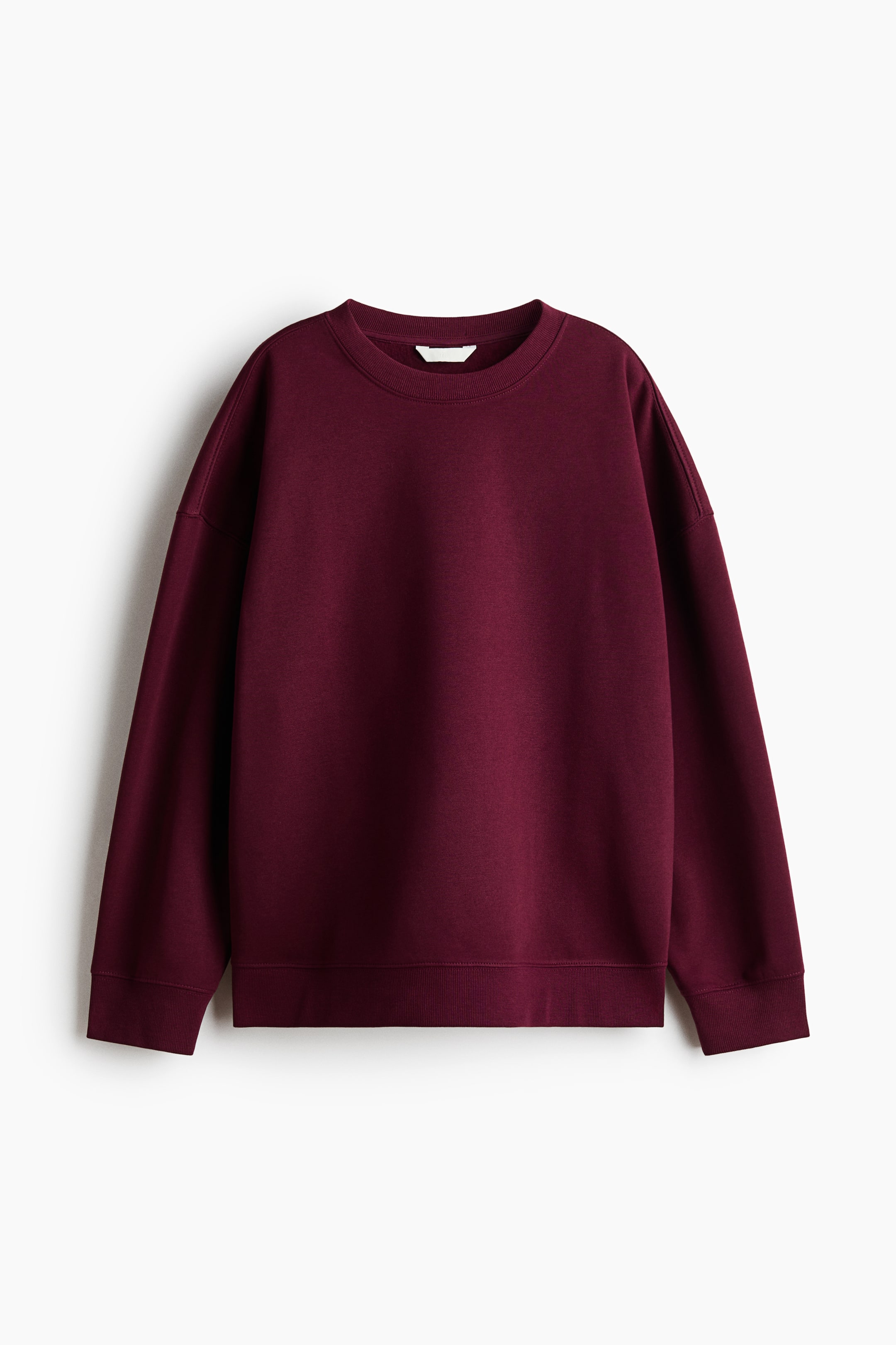View larger image: A burgundy oversized sweatshirt is shown from the front, featuring a ribbed crew neckline, dropped shoulders, long sleeves, and ribbed cuffs and hem.