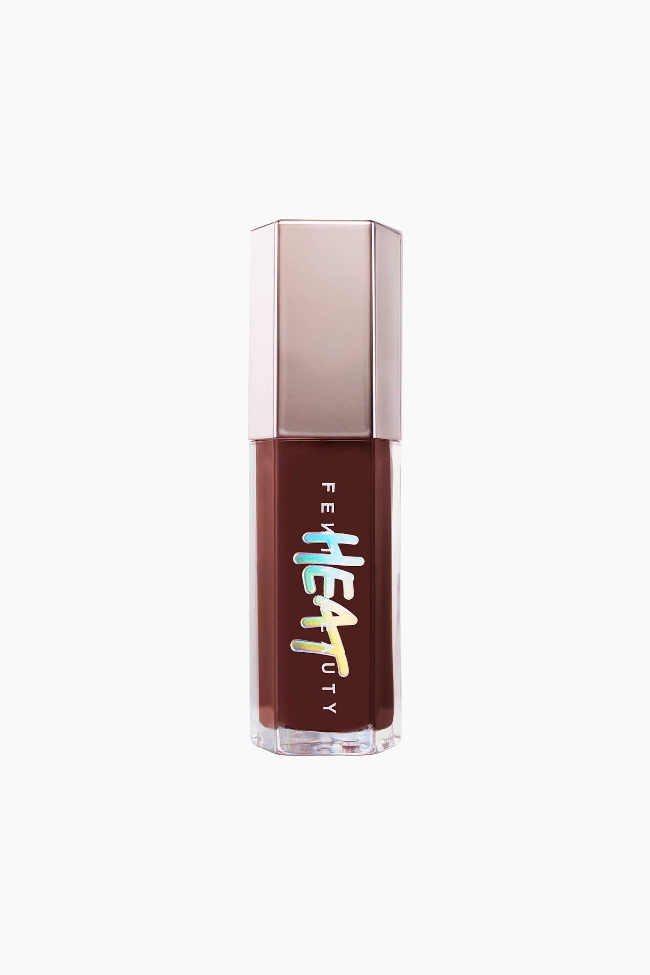 Visa större bild: Gloss Bomb Heat Universal Lip Luminizer + Plumper står upprätt och visar upp sin klara, hexagonala flaska fylld med ett djupt brunfärgat läppglans och toppad med ett metalliskt roséguldfärgat hexagonalt lock. På flaskans framsida finns den vertikala logotypen ”FENTY BEAUTY” överlagrad med en framträdande, iriserande holografisk ”HEAT”-grafik i en droppande fonstil.