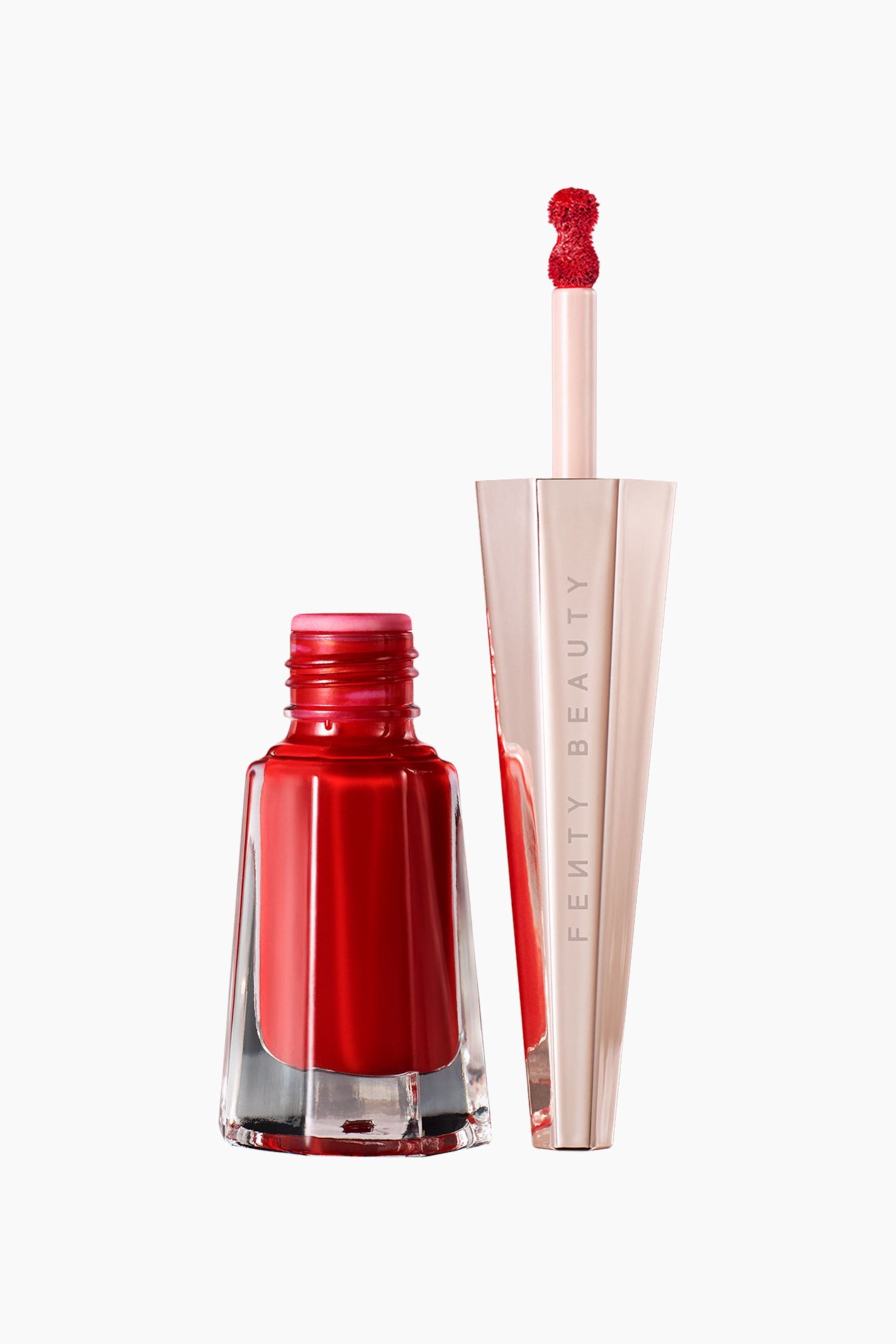 Visa större bild: Stunna Lip Paint Longwear Fluid Lip Color står upprätt och visar en öppen, facetterad glasflaska fylld med livfullt rött flytande läppstift bredvid den höga, geometriska roseguldfärgade korken. Korken vilar vertikalt för att avslöja den fästa applikatorn, som pekar uppåt med en precisionsspets i svampform, täckt av den röda läppfärgen.