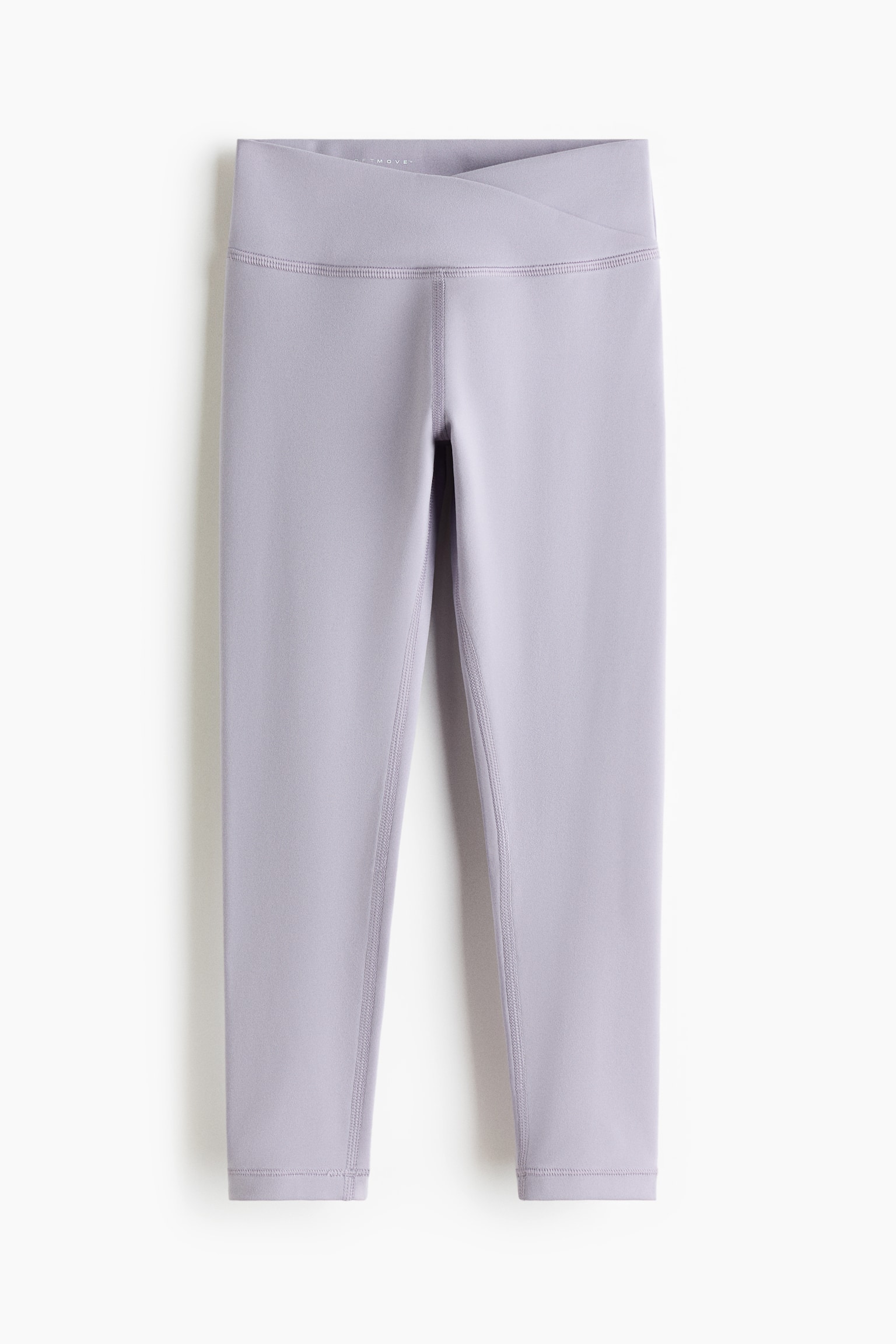 Sports leggings with SoftMove? are featuring a light purple color and a high, V-shaped crossover waistband. They are showcasing visible flatlock seams along the legs and a cropped length. - 1