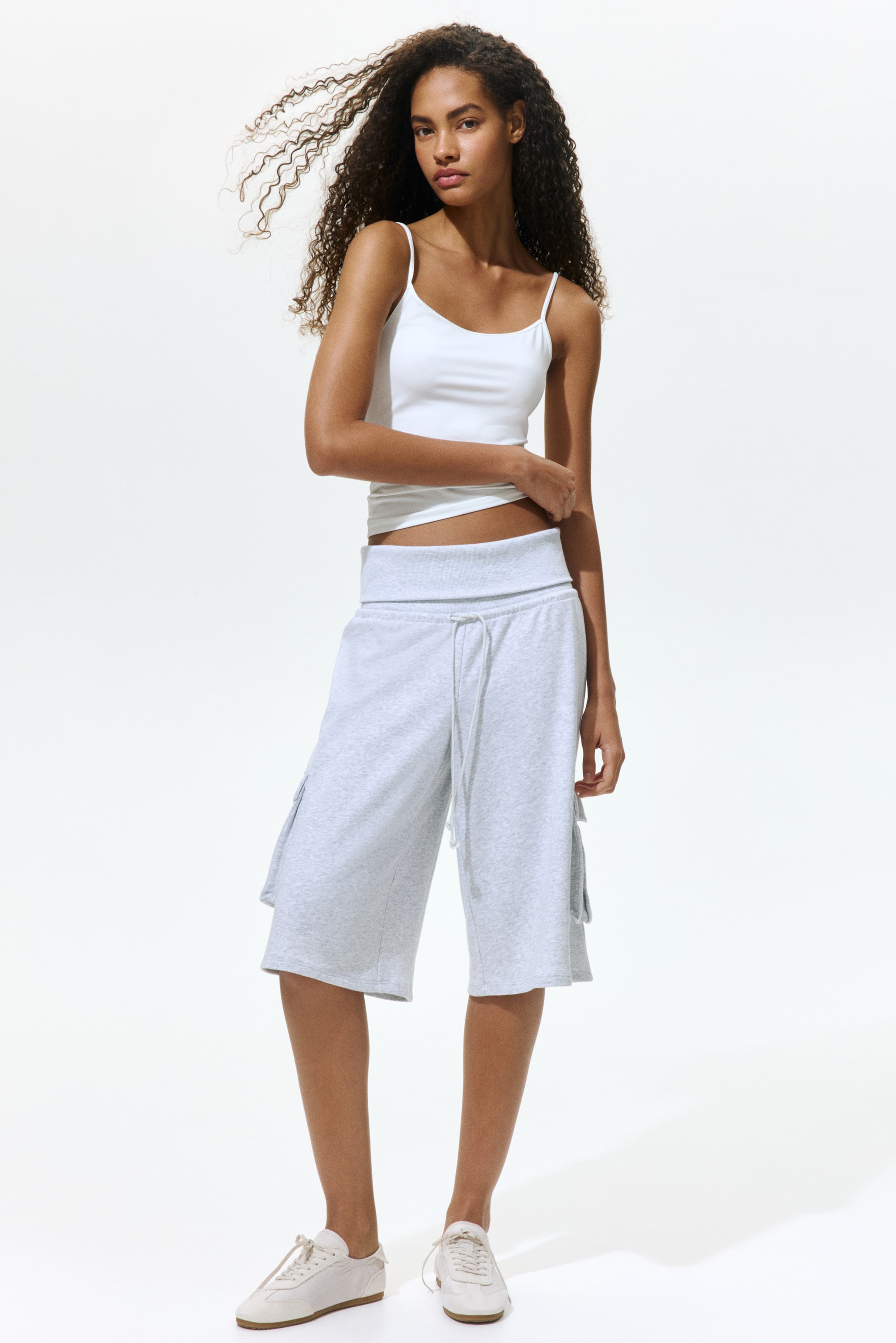 View larger image: Light gray mélange jersey shorts na may malapad na nakatuping baywang at nakikitang drawstrings sa harap, at may mga cargo pocket sa gilid, umaabot hanggang bahagyang ibaba ng tuhod.