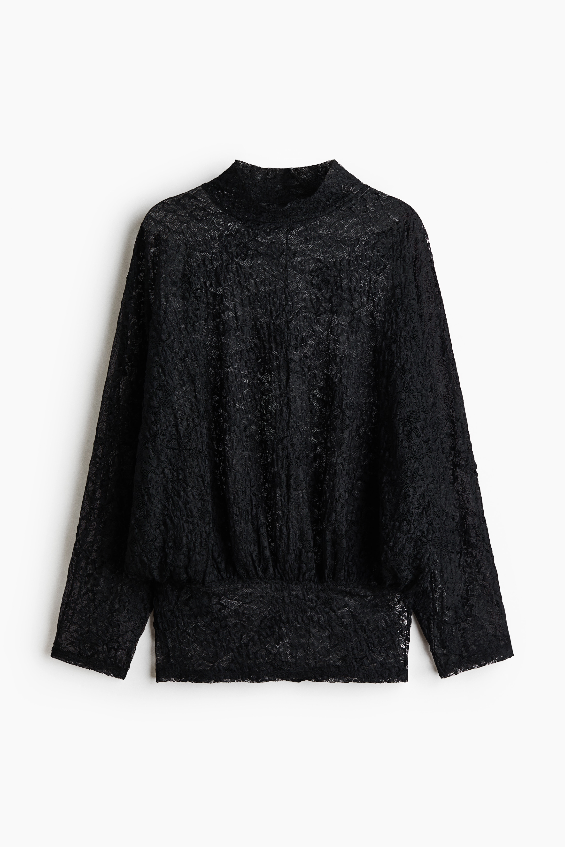 A black semi-sheer lace top with a stand collar and wide, long sleeves is worn by the model over a black bralette. The loose-fitting top features an intricate floral pattern, with the sleeves draping outward as the model poses with her hands on her hips.
