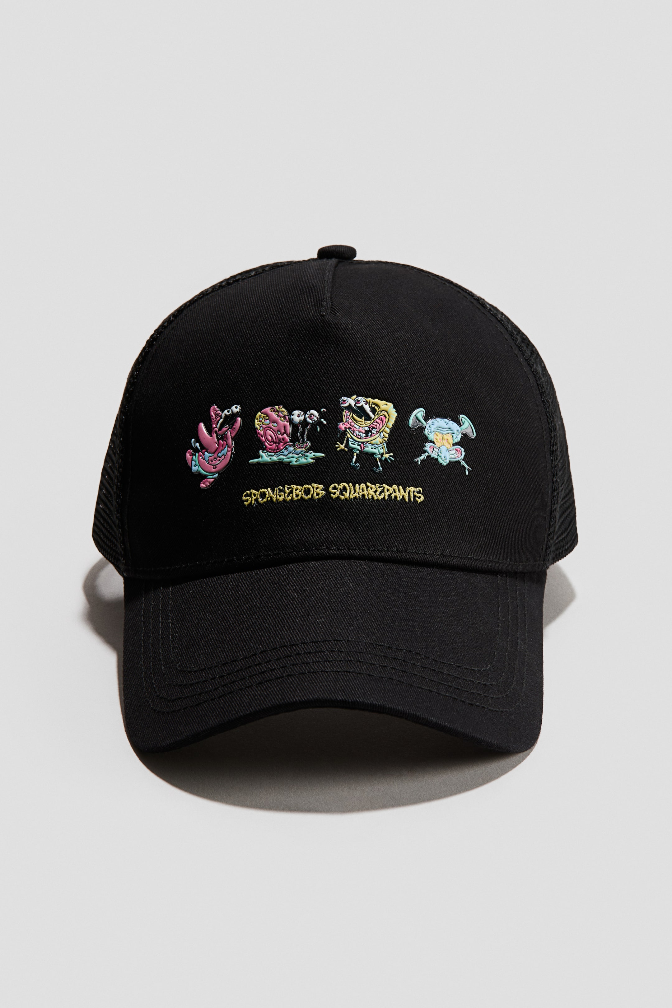 Grösseres Bild ansehen: Ein schwarzes Trucker-Cap zeigt nach vorne und präsentiert eine farbenfrohe Grafik stilisierter Spongebob Schwammkopf-Figuren sowie den Schriftzug "SPONGEBOB SQUAREPANTS" auf der soliden schwarzen Stofffront. Schwarzes Netz bildet die Seiten- und Rückenteile des Caps.