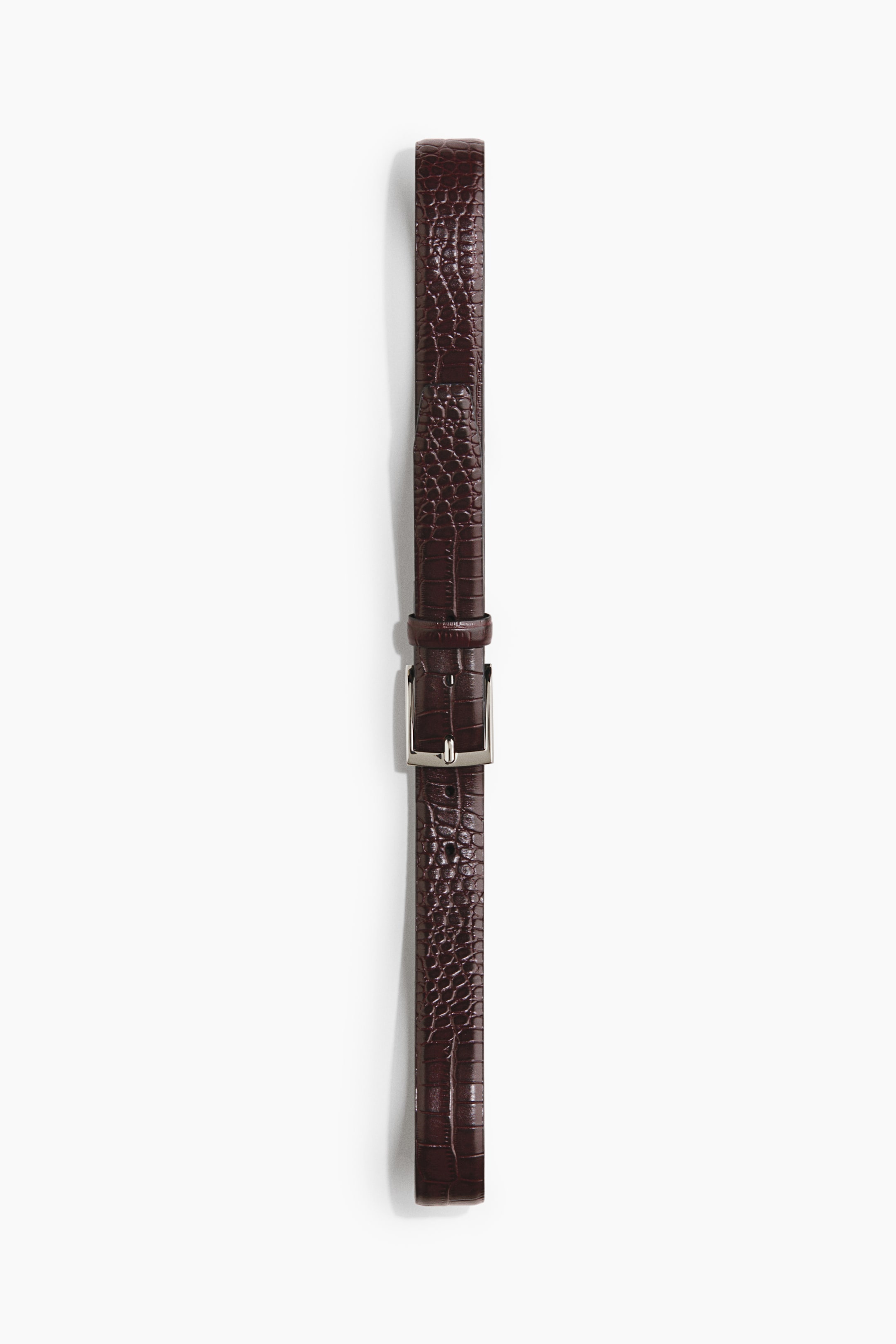 View larger image: A dark brown leather belt with an embossed crocodile texture is lying flat vertically. It features a silver-toned square metal buckle at its centre.