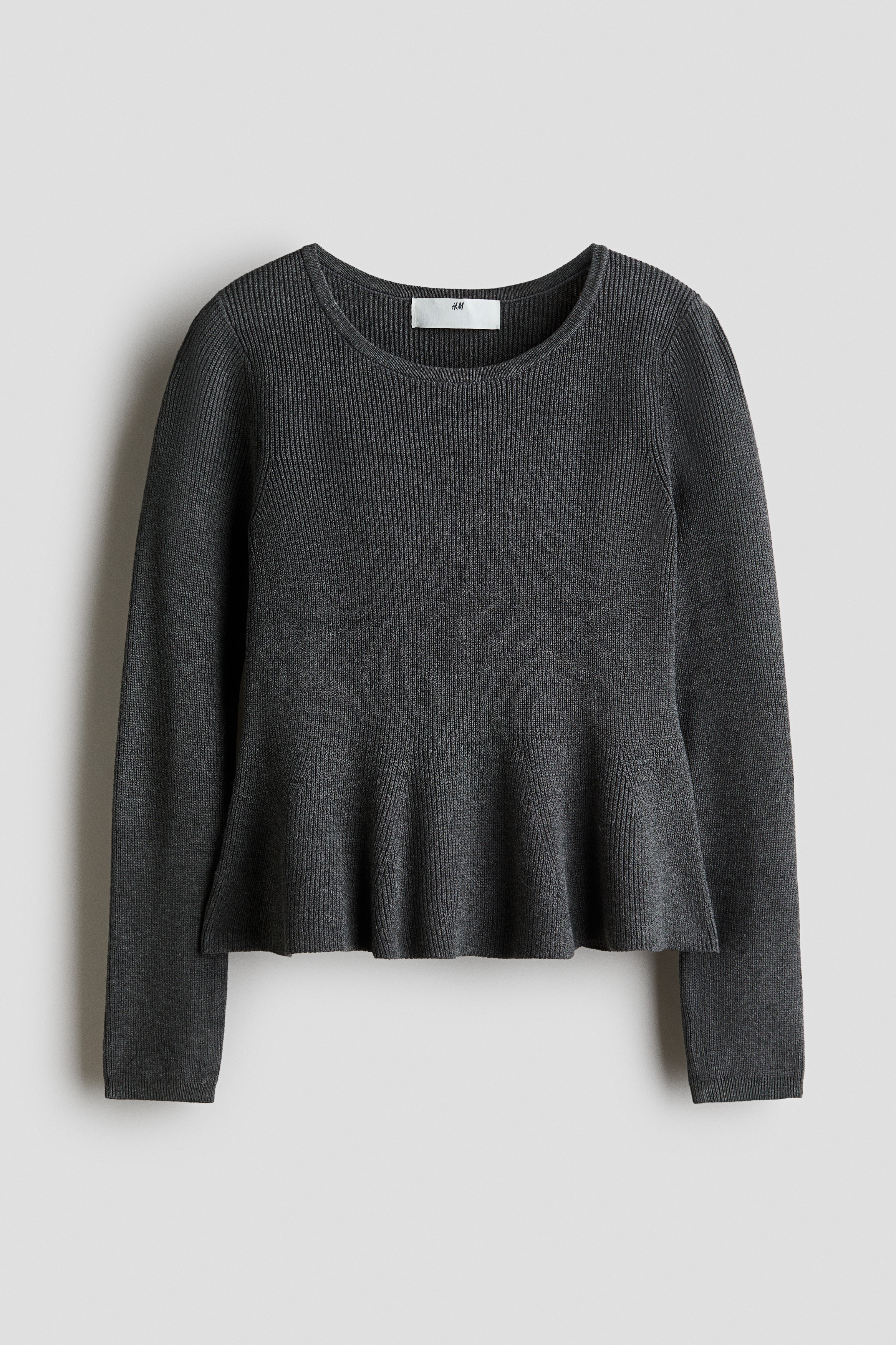 Un chandail en tricot cÃ´telÃ© gris foncÃ© est montrÃ© de face, avec un col rond, des manches longues et un ourlet pÃ©plum Ã©vasÃ©.