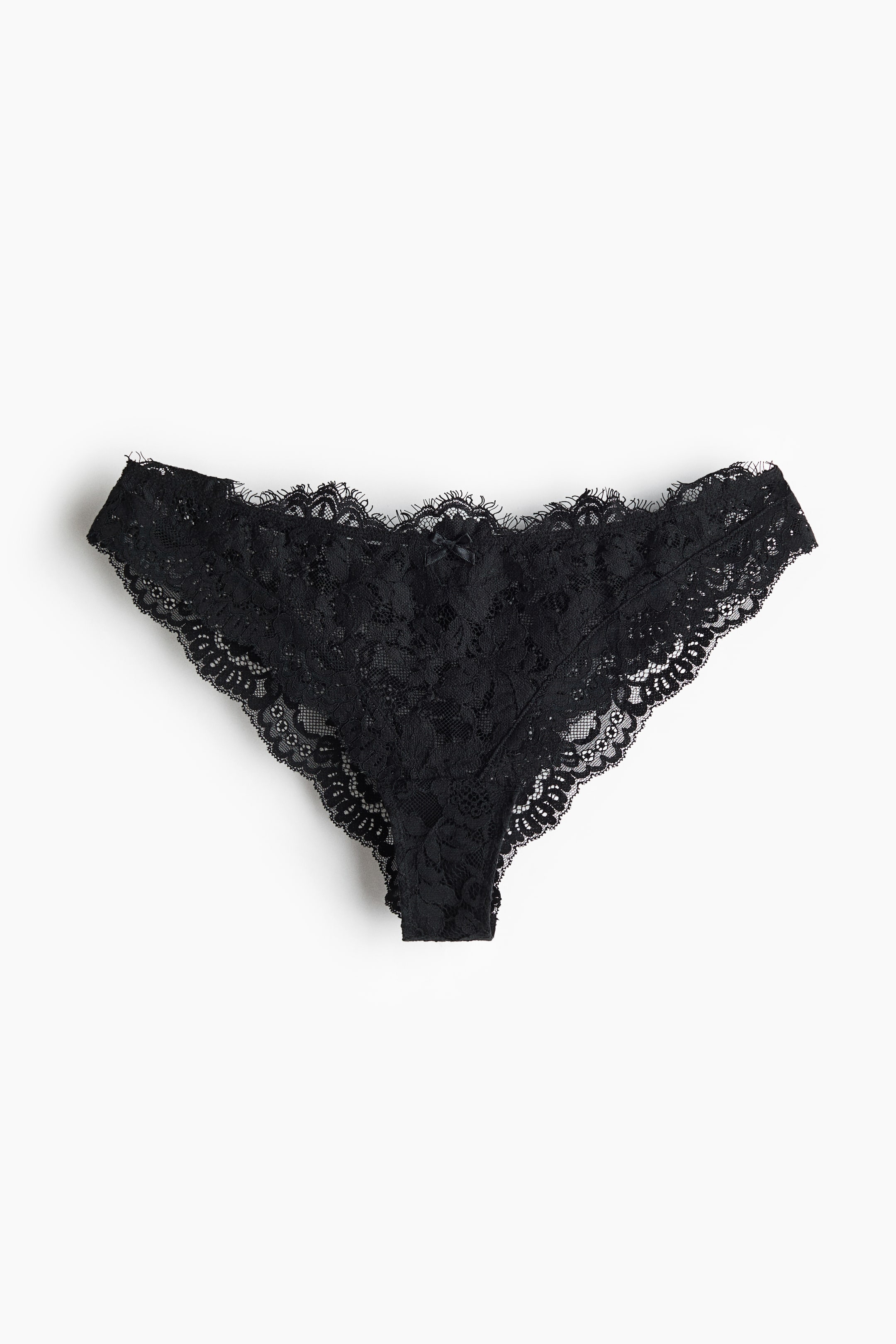 Größeres Bild anzeigen: Schwarze Spitzen-Stringunterwäsche mit filigranen floralen Spitzenmustern und gewellten Abschlüssen, verziert mit einer kleinen schwarzen Satinschleife in der Mitte des Bundes.