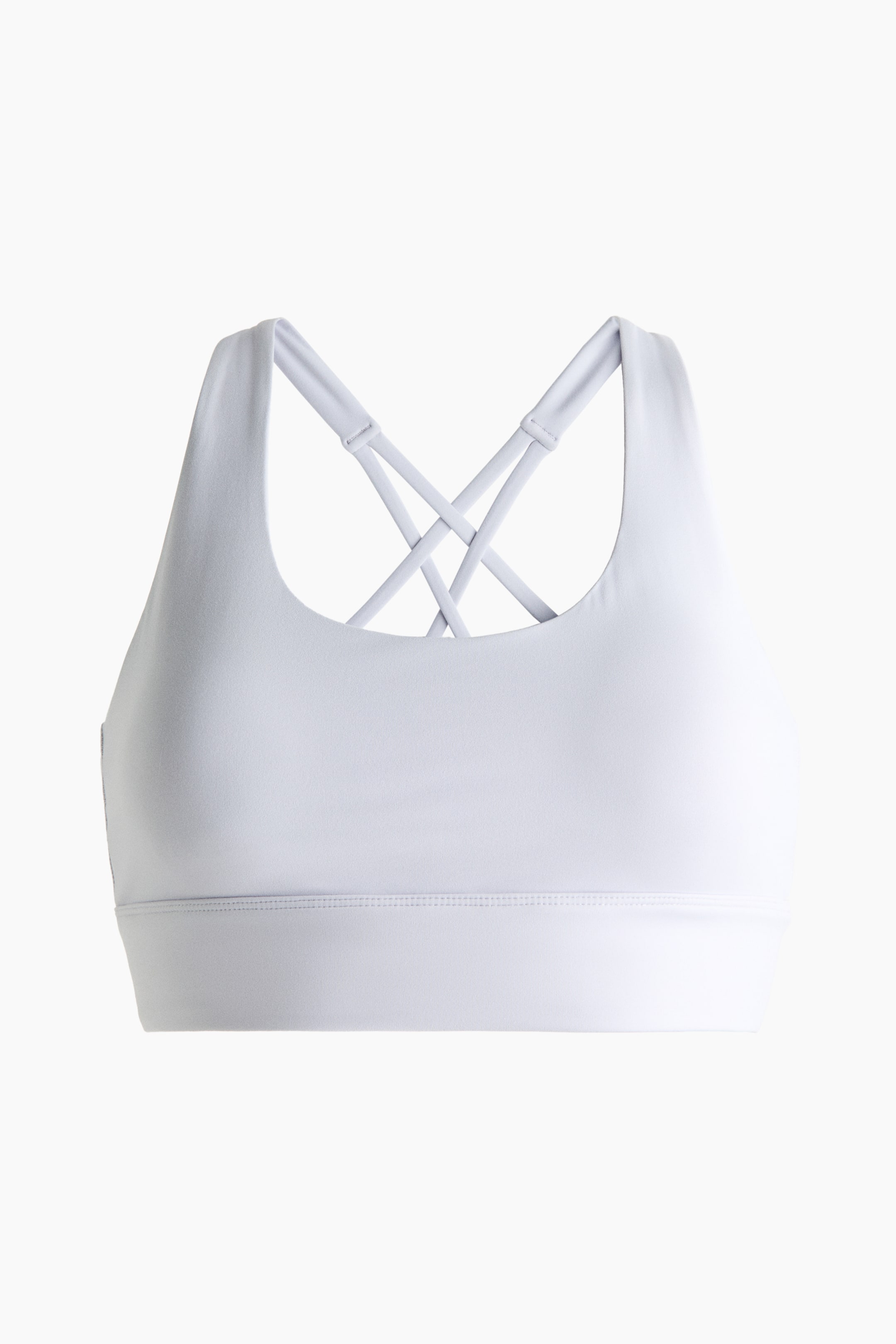 View larger image: A white sports bra is facing front, showcasing a smooth, matte fabric with a wide elastic band at the bottom. The back of the bra highlights multiple crisscrossing straps.