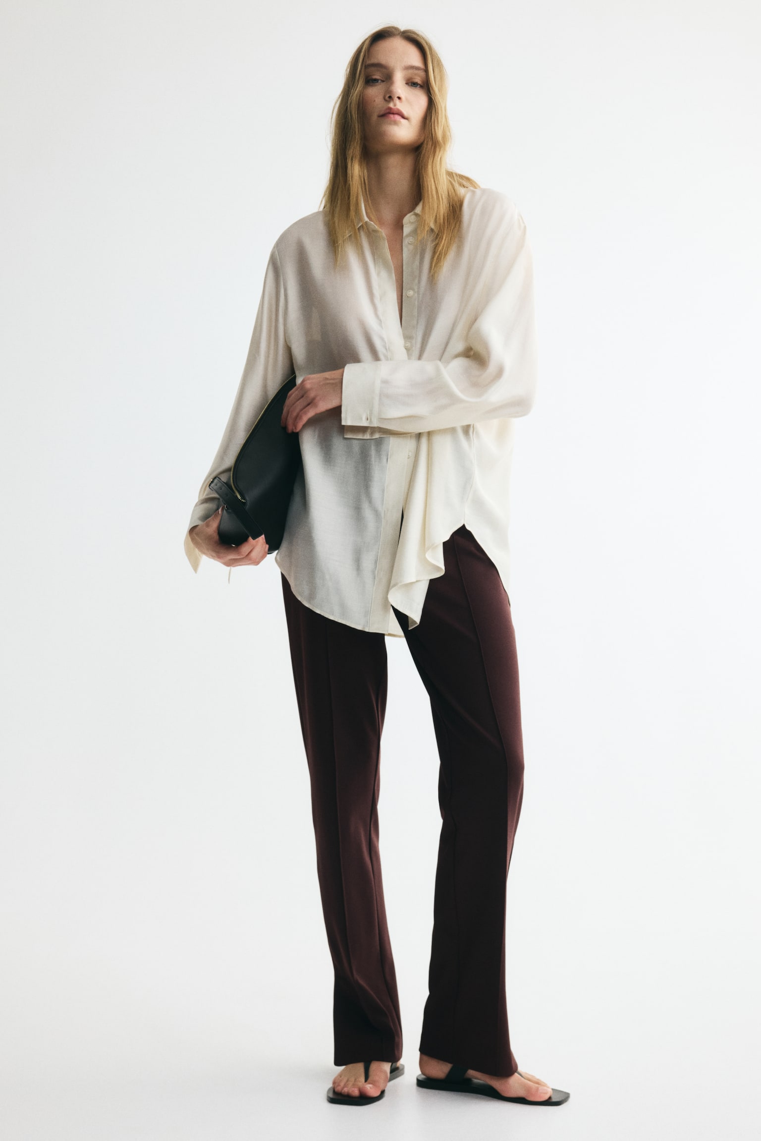 Dark red trousers feature a flat-front waistband with vertical stitched creases running down the front of each straight, slightly cropped leg. - 1