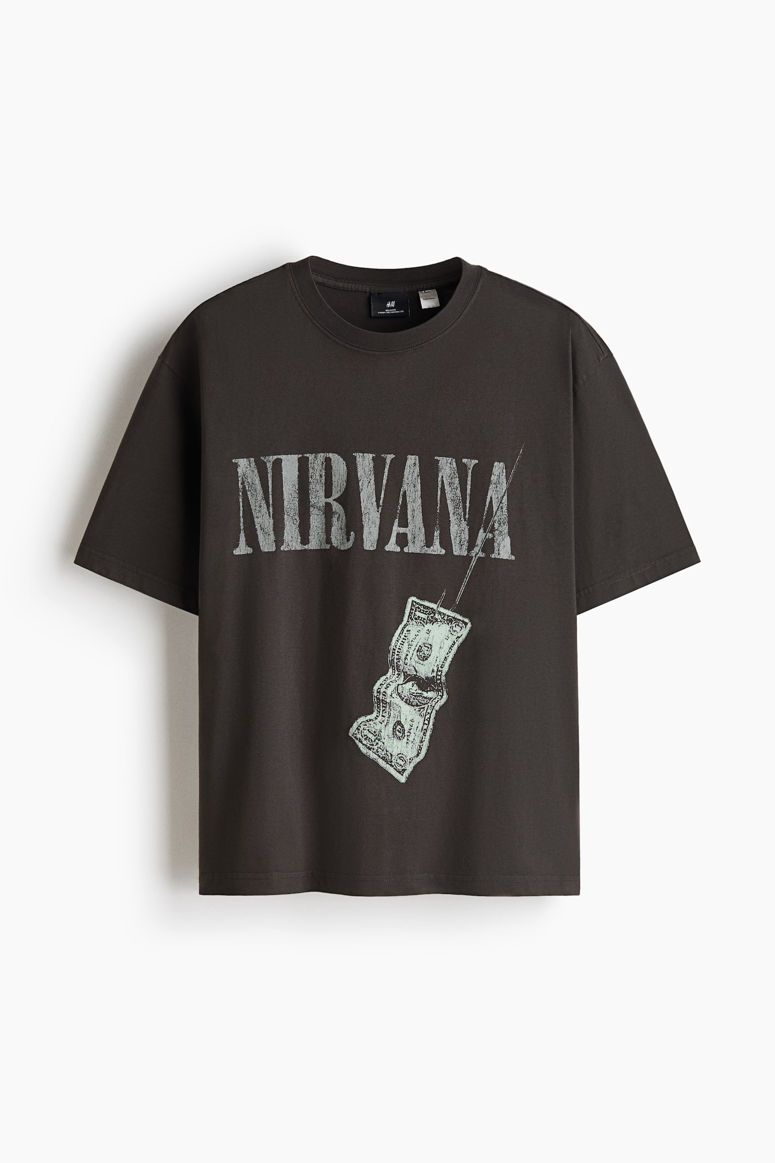 A dark gray, relaxed-fit T-shirt is shown from the front, featuring a round, rib-trimmed neckline, dropped shoulders, and a straight-cut hem. The front displays a printed design with the word "NIRVANA" in a distressed, blocky font, with a graphic of a dollar bill hanging from a fishhook below it.