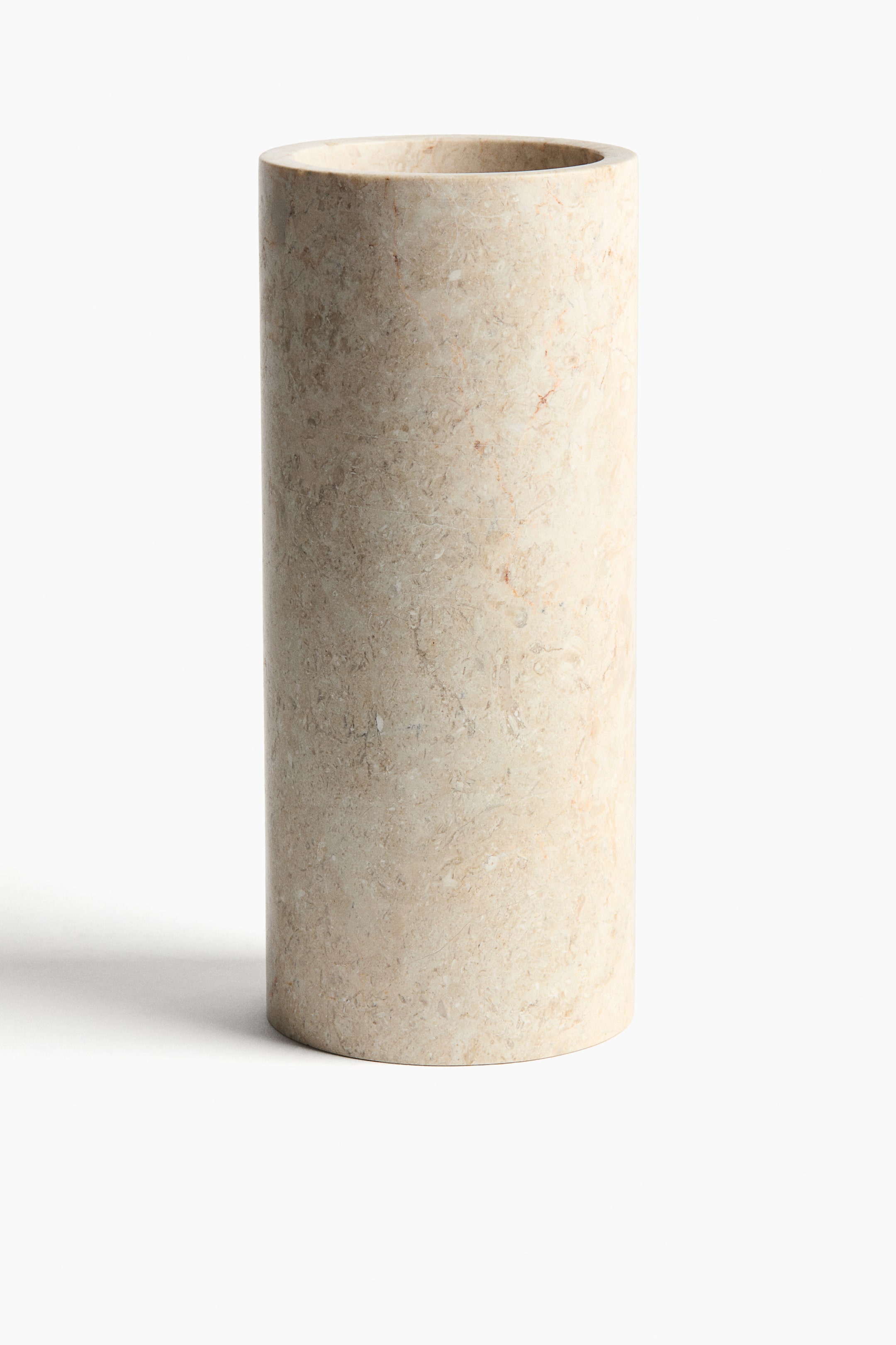 Größeres Bild ansehen: Eine zylindrische Marmorvase steht aufrecht und frontal ausgerichtet und zeigt helle Beige-Töne mit natürlicher Maserung und Sprenkelung auf der gesamten Oberfläche.