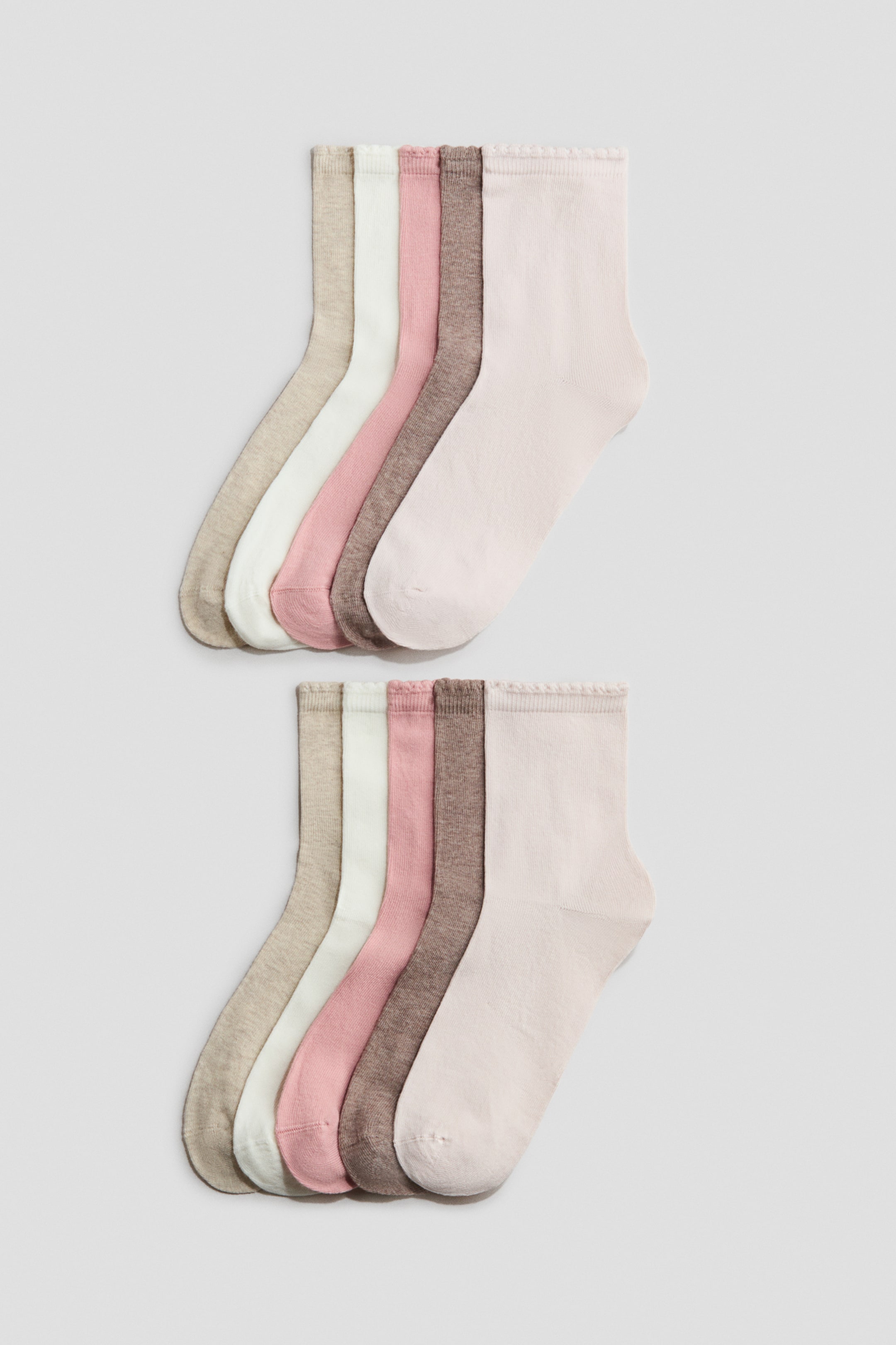 Visa större bild: Strumpor som har en mjuk, finstickad bomullsblandning med vågiga, elastiska kanter. De presenteras i två utspridda set, där varje set visar fem strumpor i ljusbeige, vit, rosa, brun och ljusrosa färger.