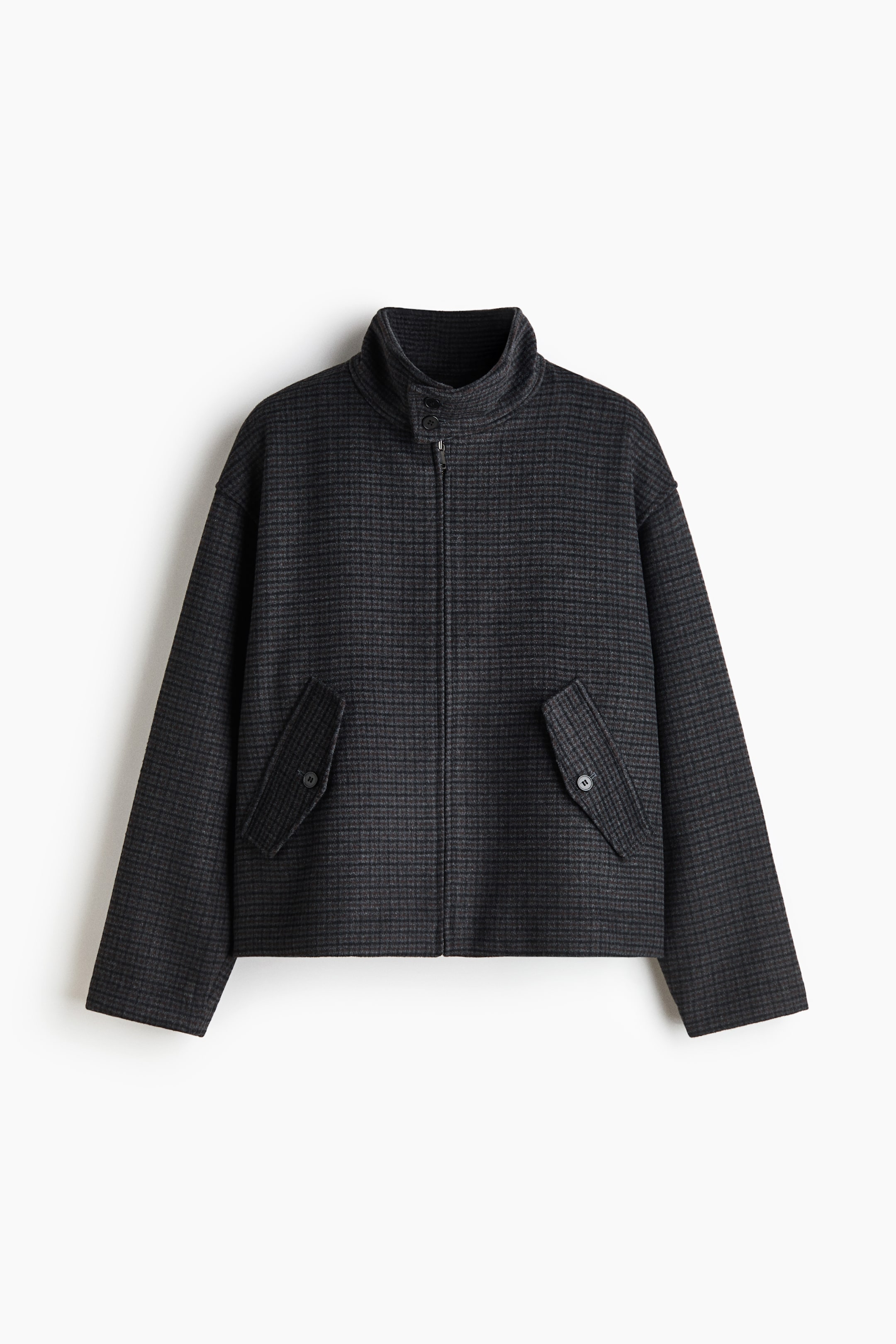 View larger image: A dark grey micro-patterned jacket is shown from the front, featuring a high funnel neck with dual button fastenings and a full-length front zip. The jacket is designed with dropped shoulders, long straight sleeves, and two angled front pockets with buttoned flaps.