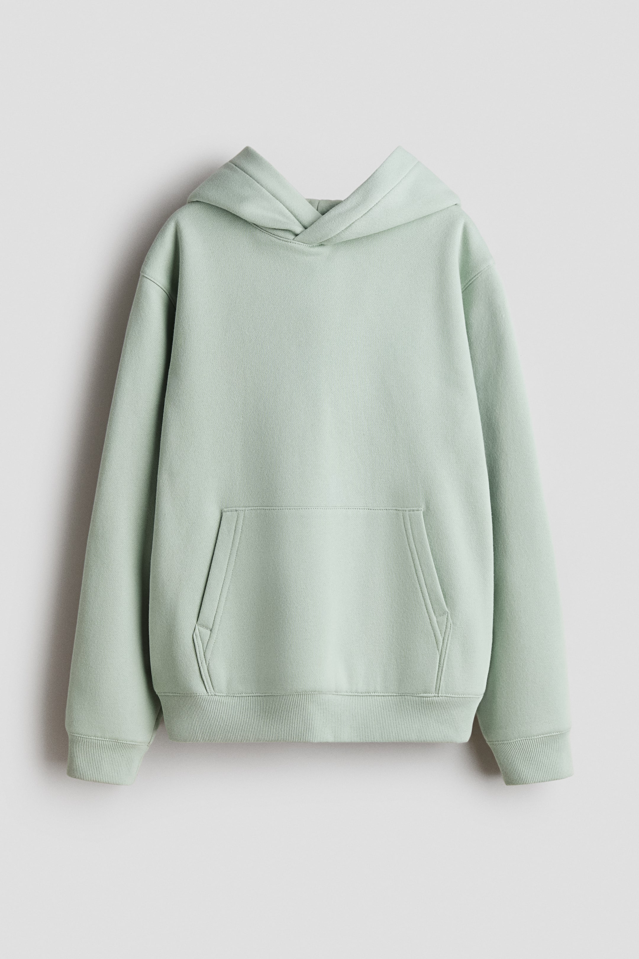 View larger image: A light green hoodie is displaying its front, featuring a double-layered, wrapover hood, dropped shoulders, long sleeves, a kangaroo pocket, and ribbed cuffs and hem.