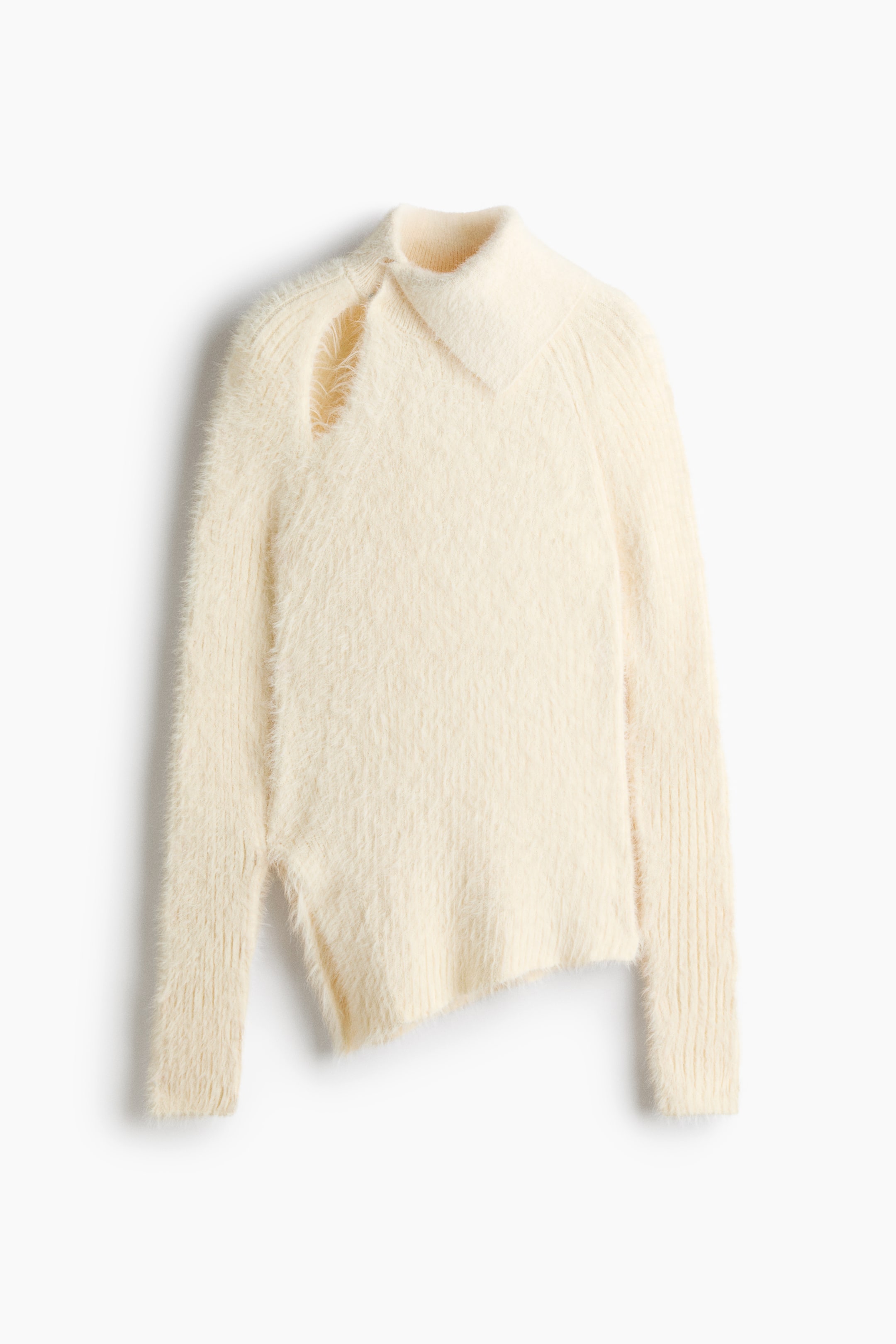 View larger image: A cream-coloured jumper in a soft, fluffy knit is shown from the front, featuring an asymmetric roll neck and a teardrop-shaped cut-out on one shoulder. It has long raglan sleeves with ribbed cuffs and an asymmetric hemline with a slit at one side.