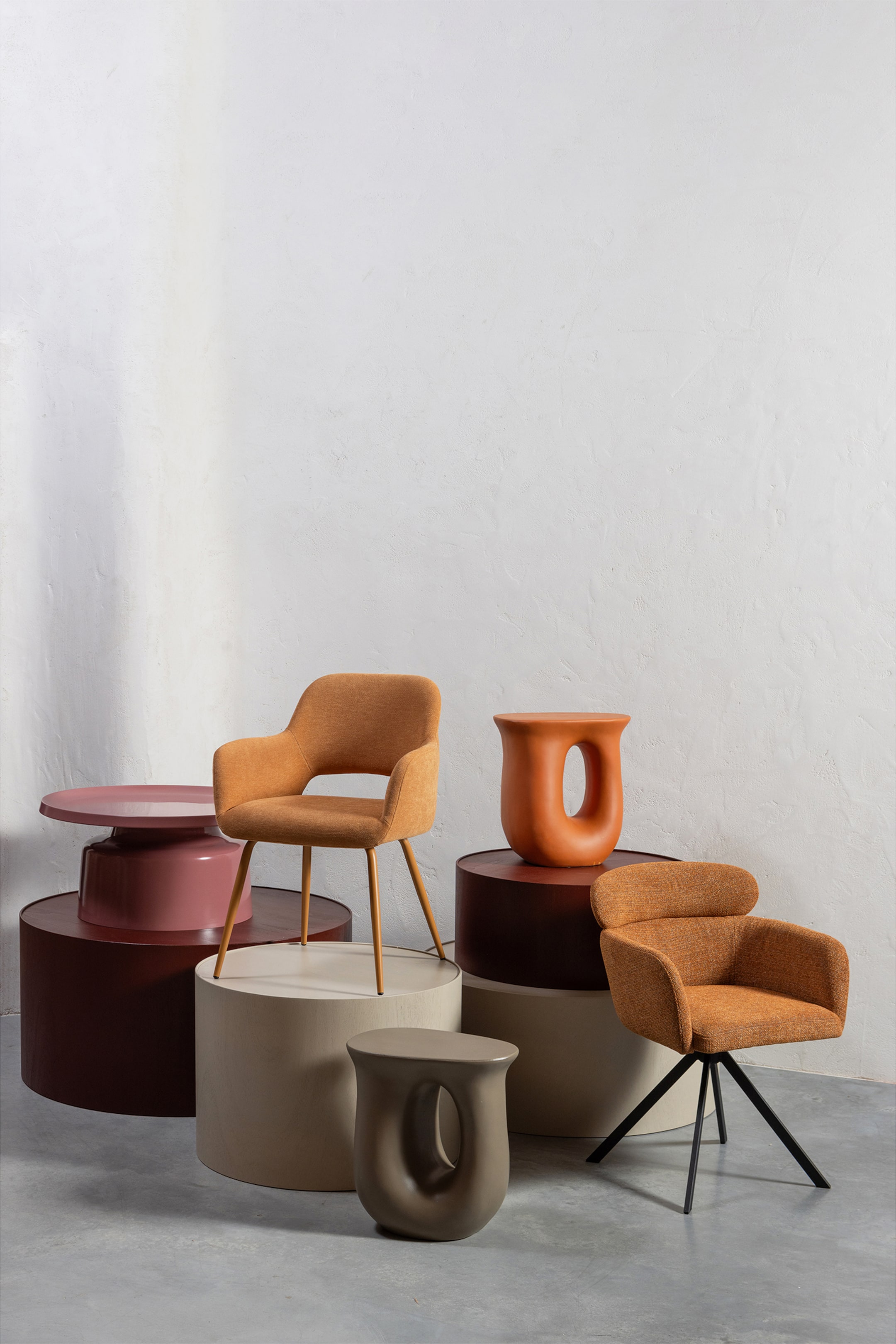 Grotere afbeelding bekijken: Een oranje gestoffeerde fauteuil presenteert zijn afgeronde rugleuning en geïntegreerde armleuningen, allemaal bedekt met een gestructureerde stof. Het beschikt over een zwarte, vierpotige stervormige basis en is iets naar links gekanteld.