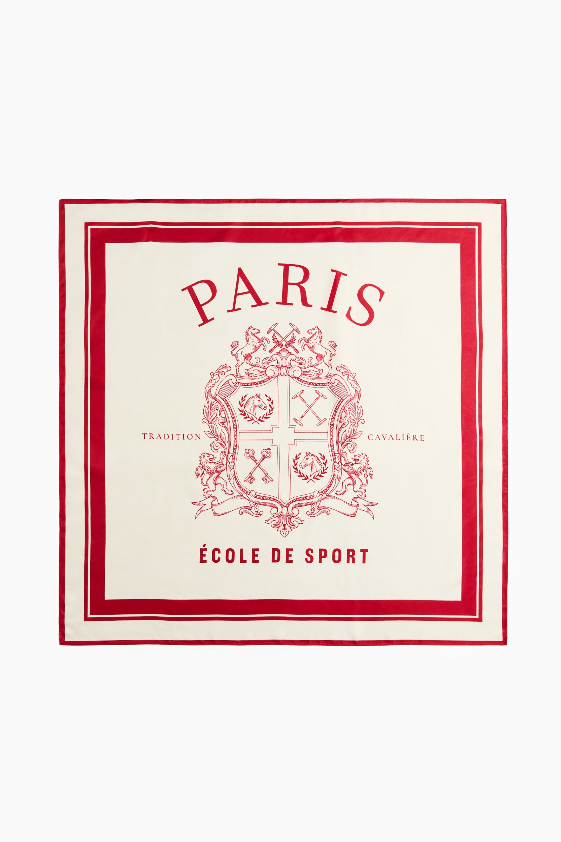 View larger image: A square scarf in a soft weave is laid flat, showcasing the front design with a cream-coloured base and a red printed pattern. The design features a double red border framing a central crest with equestrian motifs, with the word "PARIS" arched above and "ÉCOLE DE SPORT" printed below.