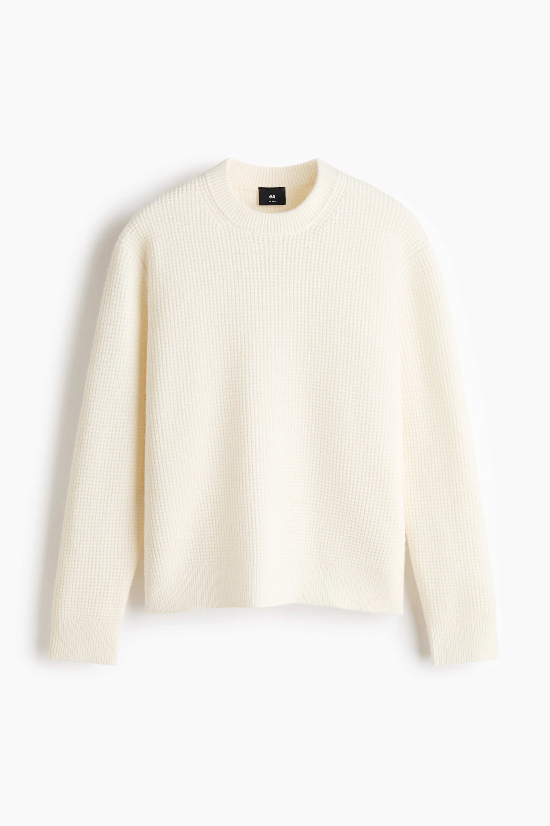 View larger image: A front-facing, off-white sweater is displaying a waffle knit texture. It features a crew neck, long sleeves, ribbed cuffs and hem, and a black H&M tag at the back of the neck.