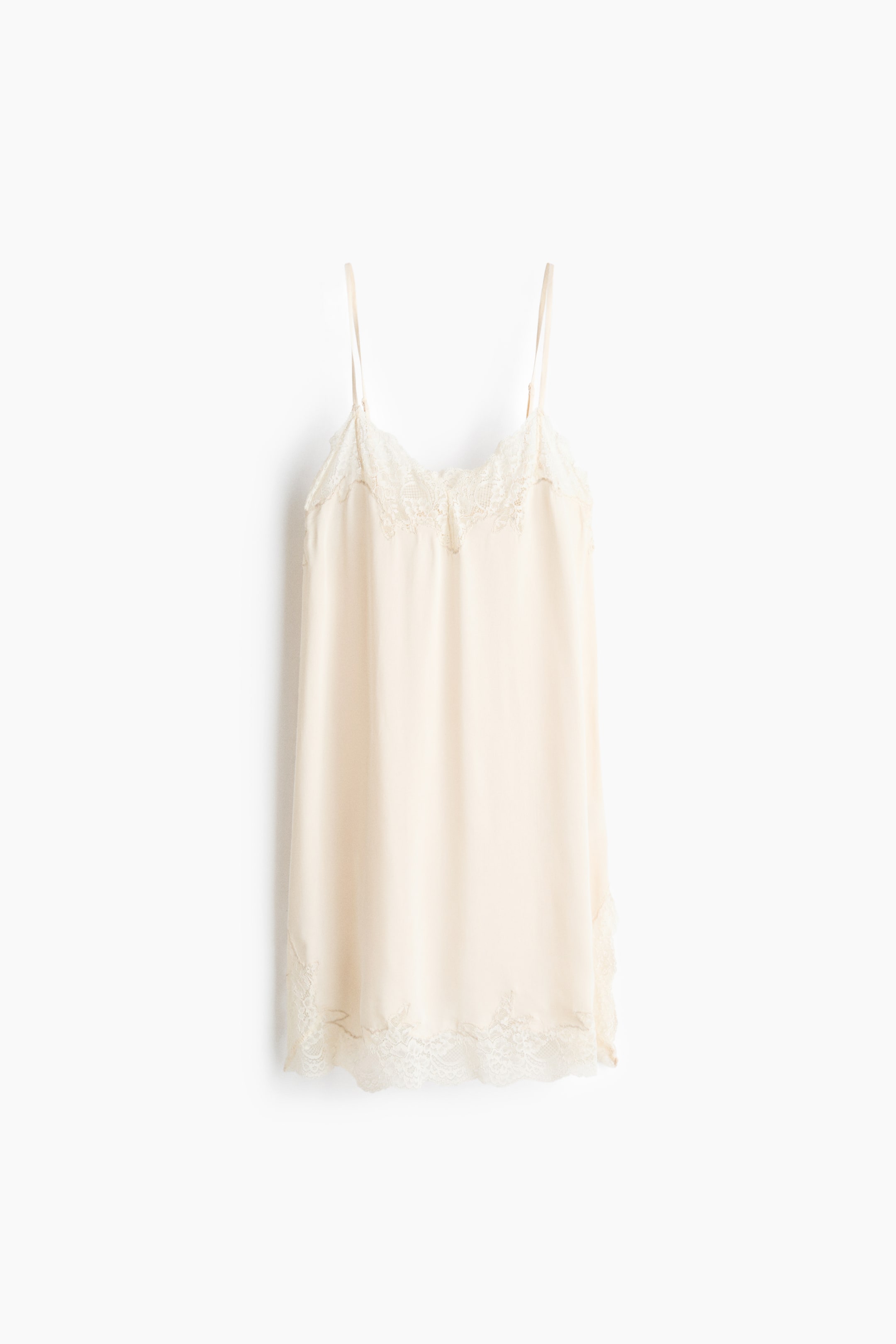 View larger image: Presenting a cream slip dress from the front, highlighted by slender spaghetti straps. The V-neckline and bottom hem are elegantly adorned with delicate lace trim.