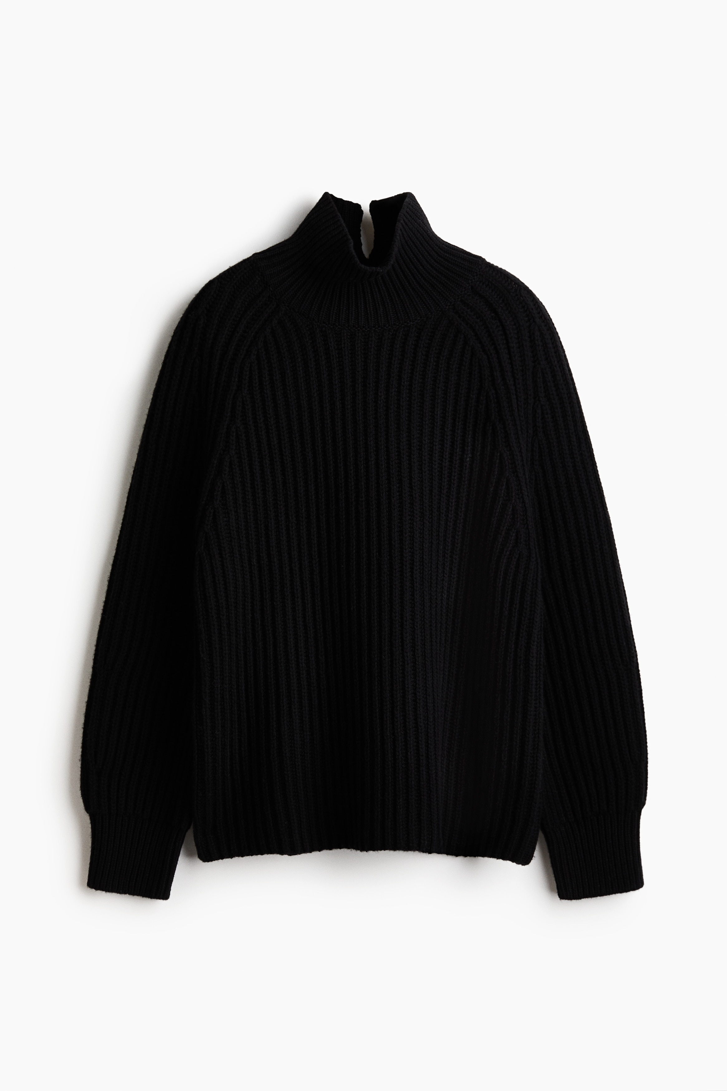 A black rib-knit sweater featuring a high neck with a V-shaped opening at the back is being worn by the model. A black leather bag is being carried over the shoulder, with its strap resting on the sweater.