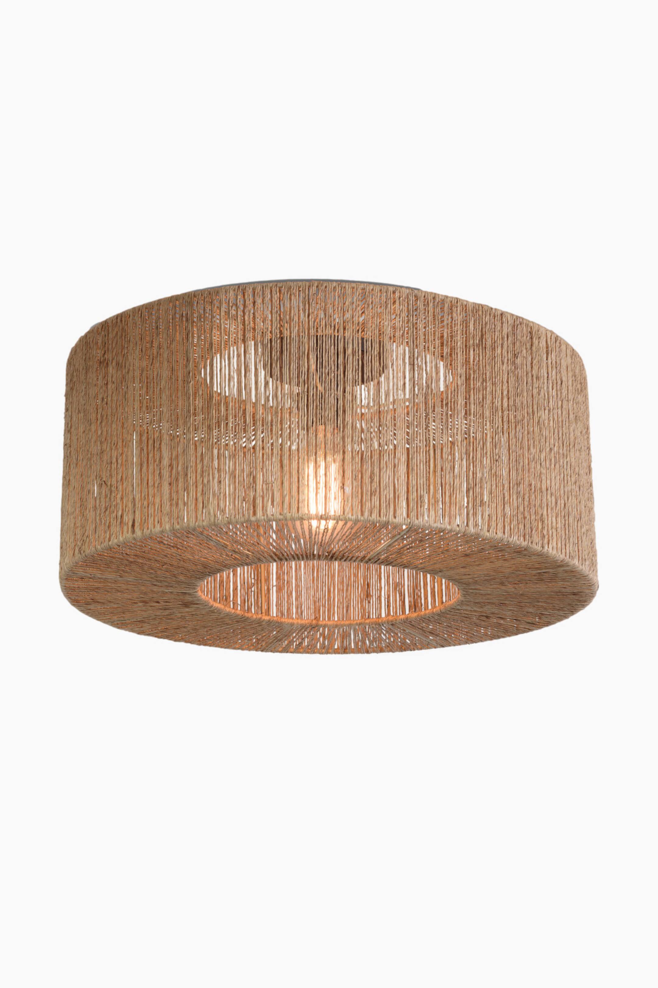 Agrandir l'image: Le plafonnier Iguazu met en valeur une structure en forme de tambour, enveloppée de cordes de jute verticales de couleur naturelle. Il est présenté sous un angle légèrement plongeant, révélant une ouverture circulaire sur le dessous ainsi qu’une ampoule lumineuse allumée au centre.