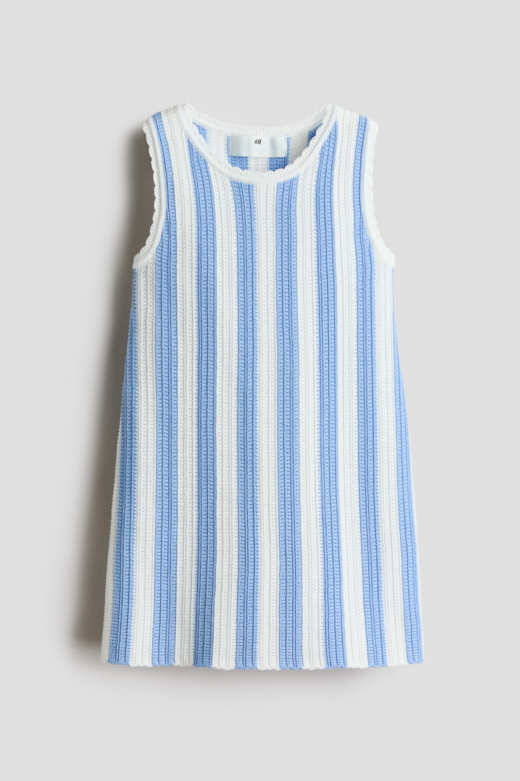 Größeres Bild ansehen: Ein strukturiertes, gestricktes ärmelloses Top mit abwechselnden vertikalen weißen und hellblauen Streifen, die nach vorne gerichtet sind. Es präsentiert einen runden Halsausschnitt mit gewellten Armausschnittkanten, und ein H&M-Label ist am hinteren Halsausschnitt sichtbar.