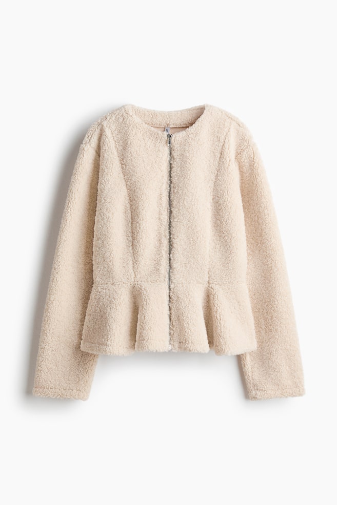 A cream teddy fleece jacket is shown from the front, featuring a round neckline and a full-length silver zip. It has long sleeves and a peplum hem at the waist, defined by vertical seams. - 1