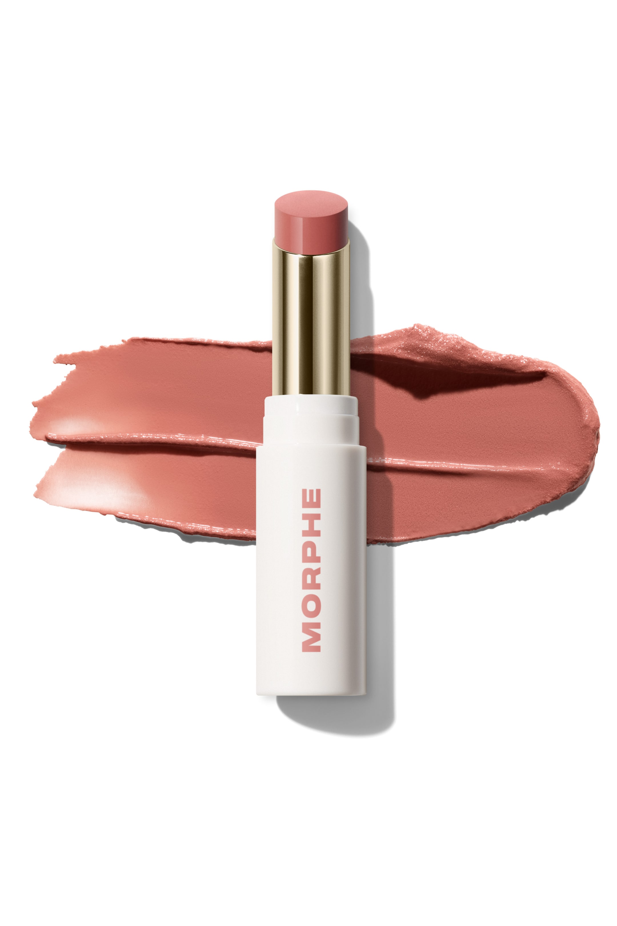Visa större bild: En Morphe persikofärgad-rosa sminksticka ligger horisontellt, dess vita tub har "MORPHE" vertikalt och ett guldband separerar produkttippen från tuben. En texturerad swatch av den persikofärgade-rosa produkten visas bredvid stickan.