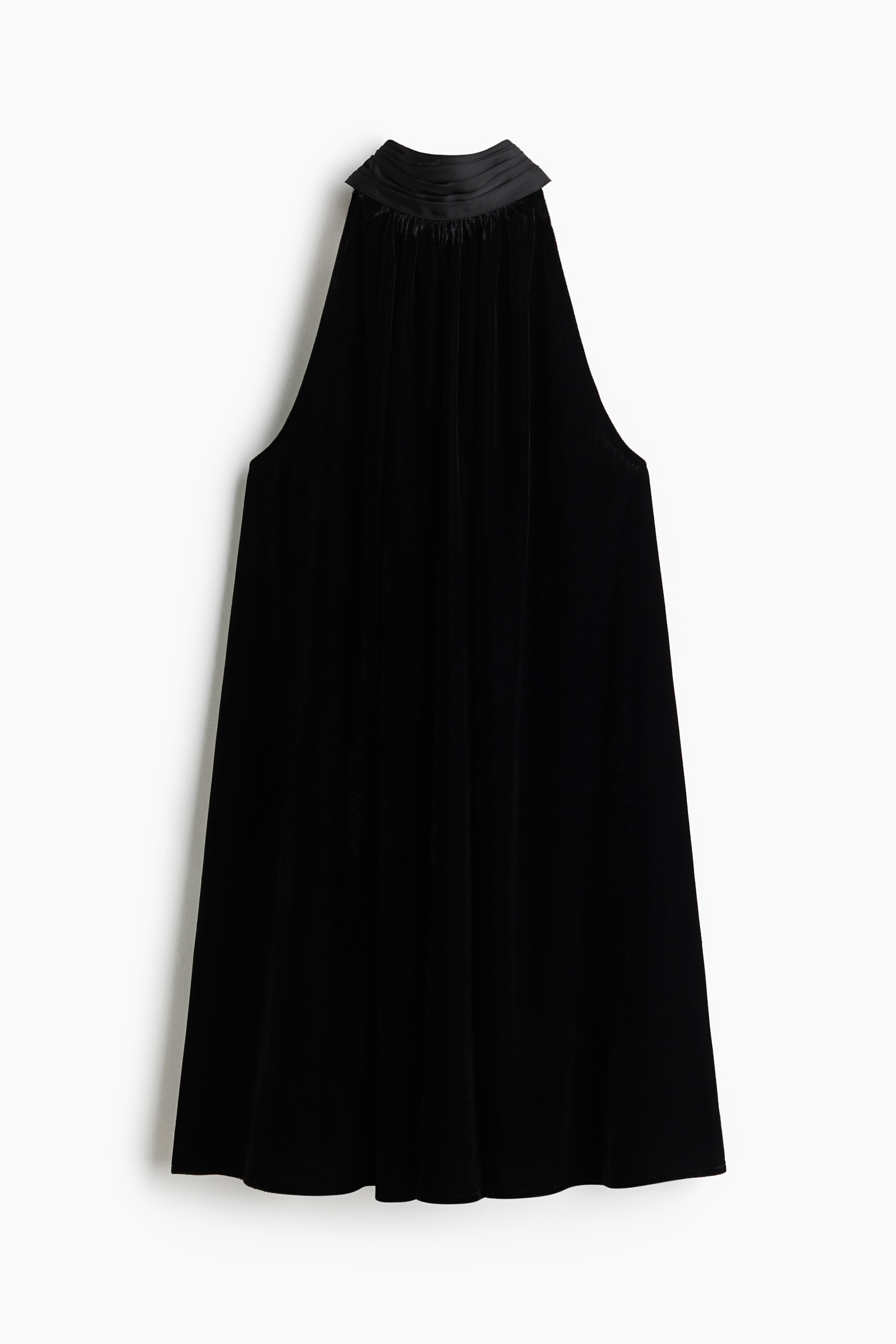 A short black A-line dress with a pleated high stand collar and a sleeveless halter-neck cut is worn by the model. The loose-fit dress is styled with black pointed-toe heels.