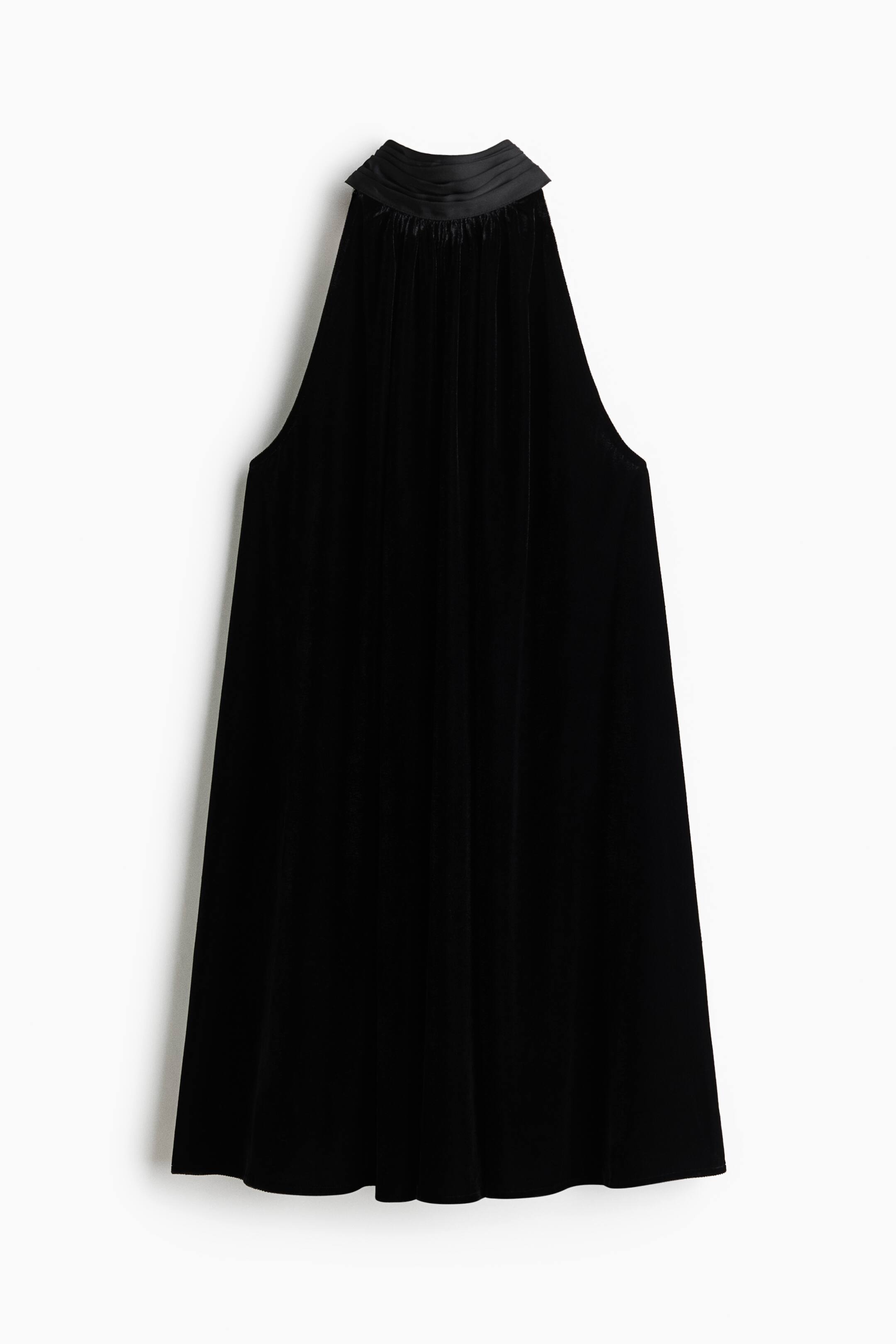 View larger image: A black velvet halter dress is hanging in a front-facing view, featuring a high, gathered satin collar and deep-cut sleeveless armholes. The dress drapes downwards in a loose A-line silhouette with subtle pleating originating from the neckline.
