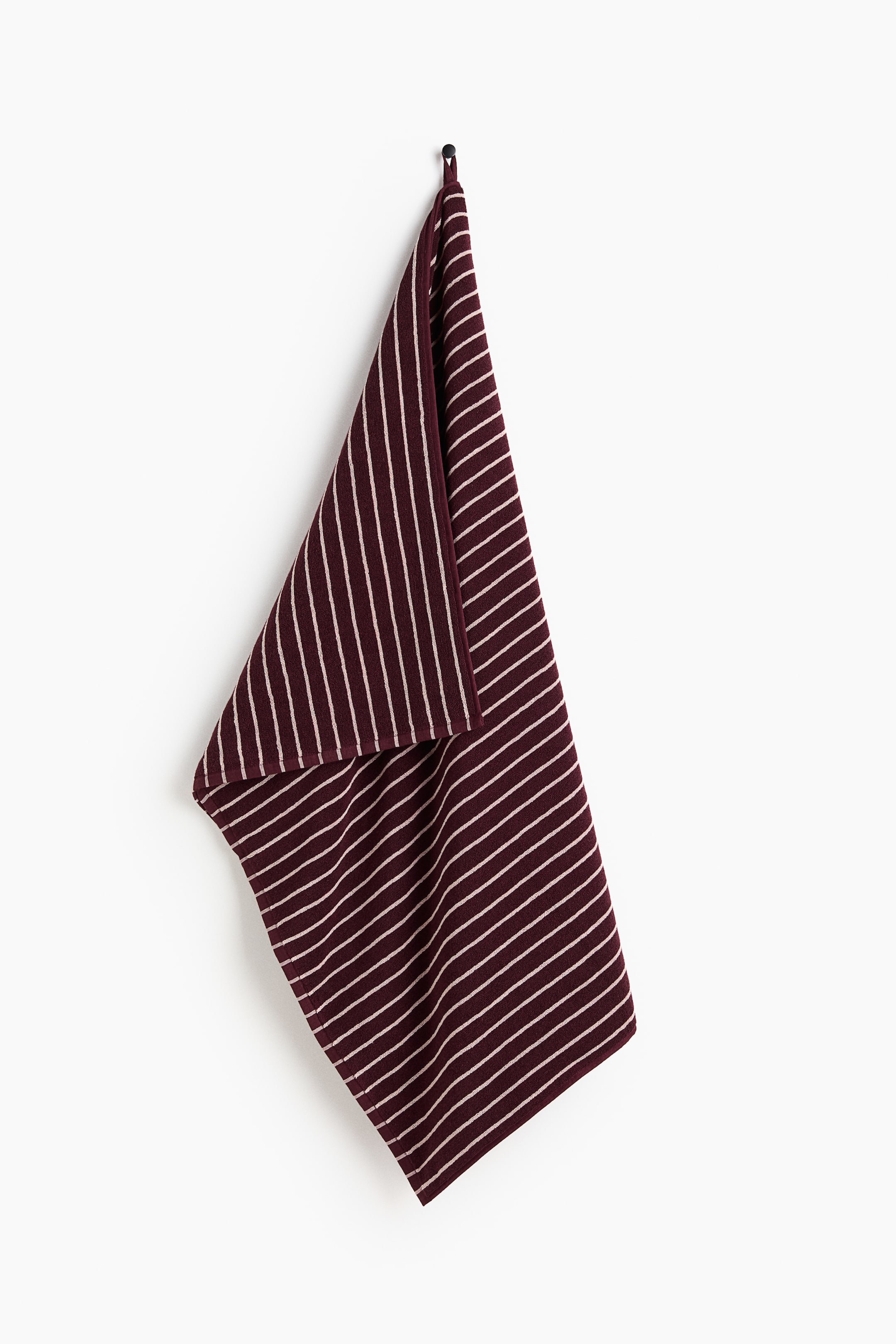 View larger image: A bath sheet in soft cotton terry is hanging, showcasing a classic striped print. A loop is visible on one long side, providing a hanging option.