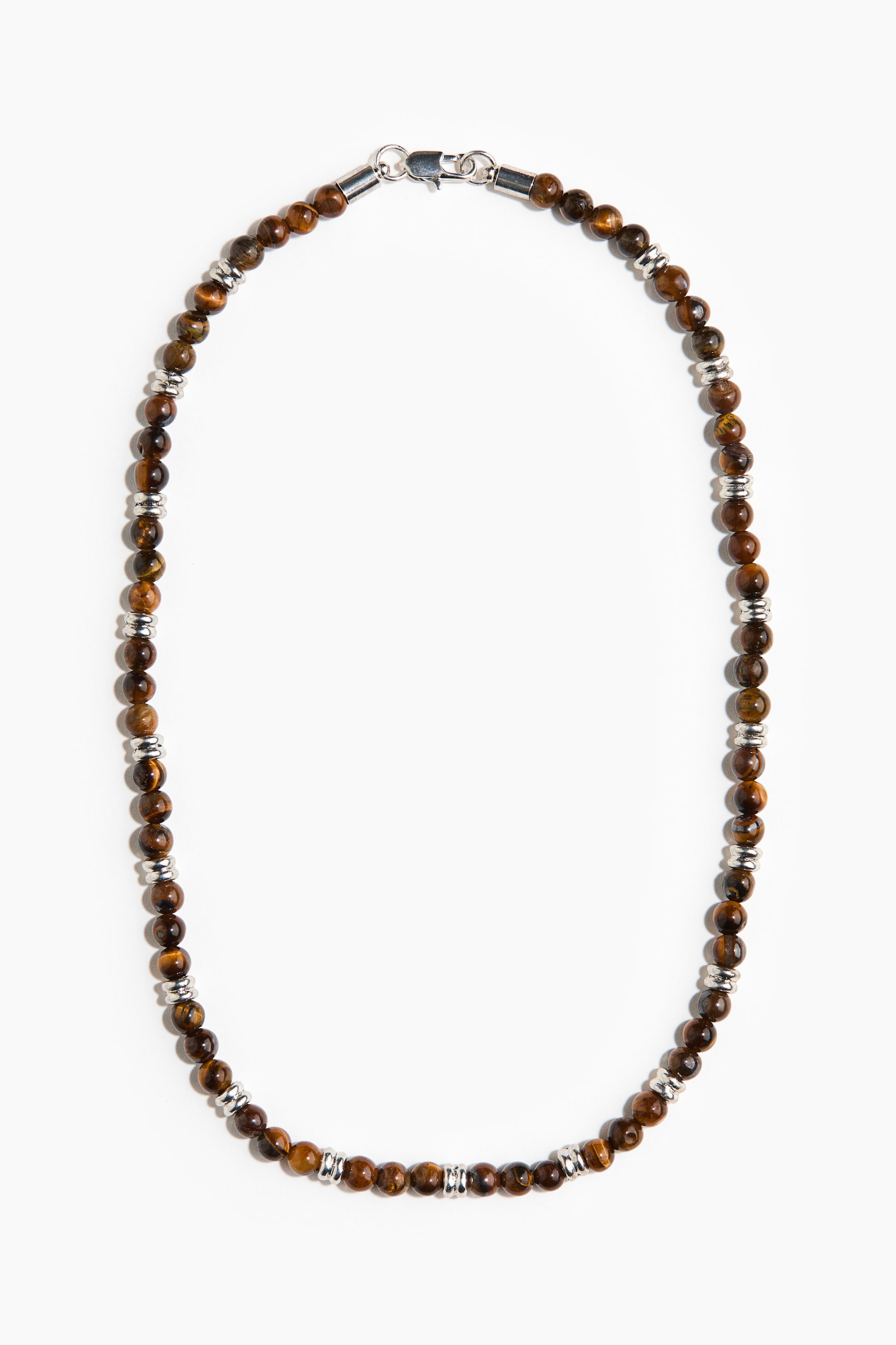 View larger image: The necklace features round, brown tiger's eye beads alternating with small, silver-toned cylindrical spacers. The ends of the necklace are secured with a silver-toned lobster clasp.