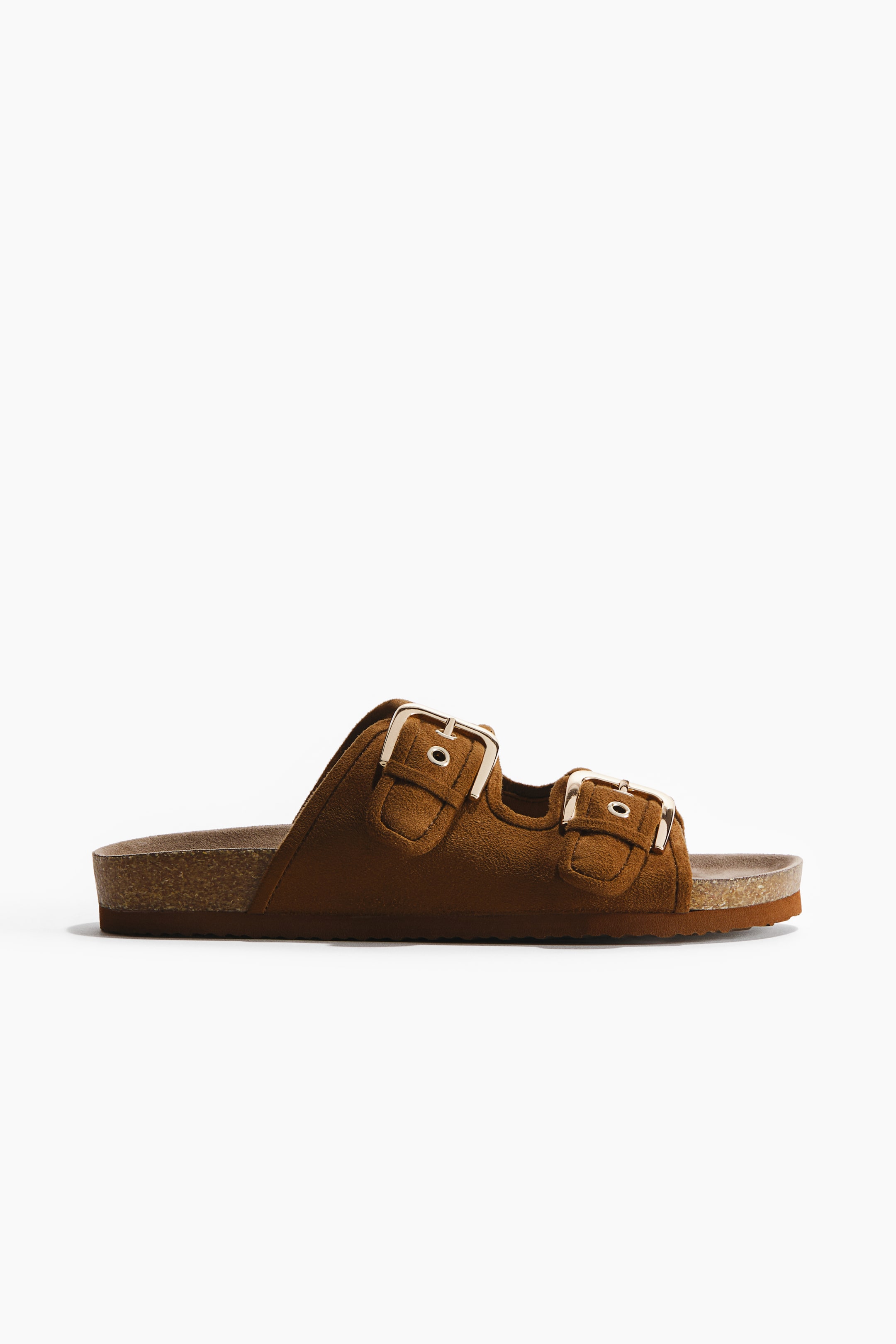 View larger image: A brown suede-like sandal featuring two adjustable foot straps, each secured with a gold-toned metal buckle. It showcases a moulded insole, a cork midsole, and a patterned outsole.