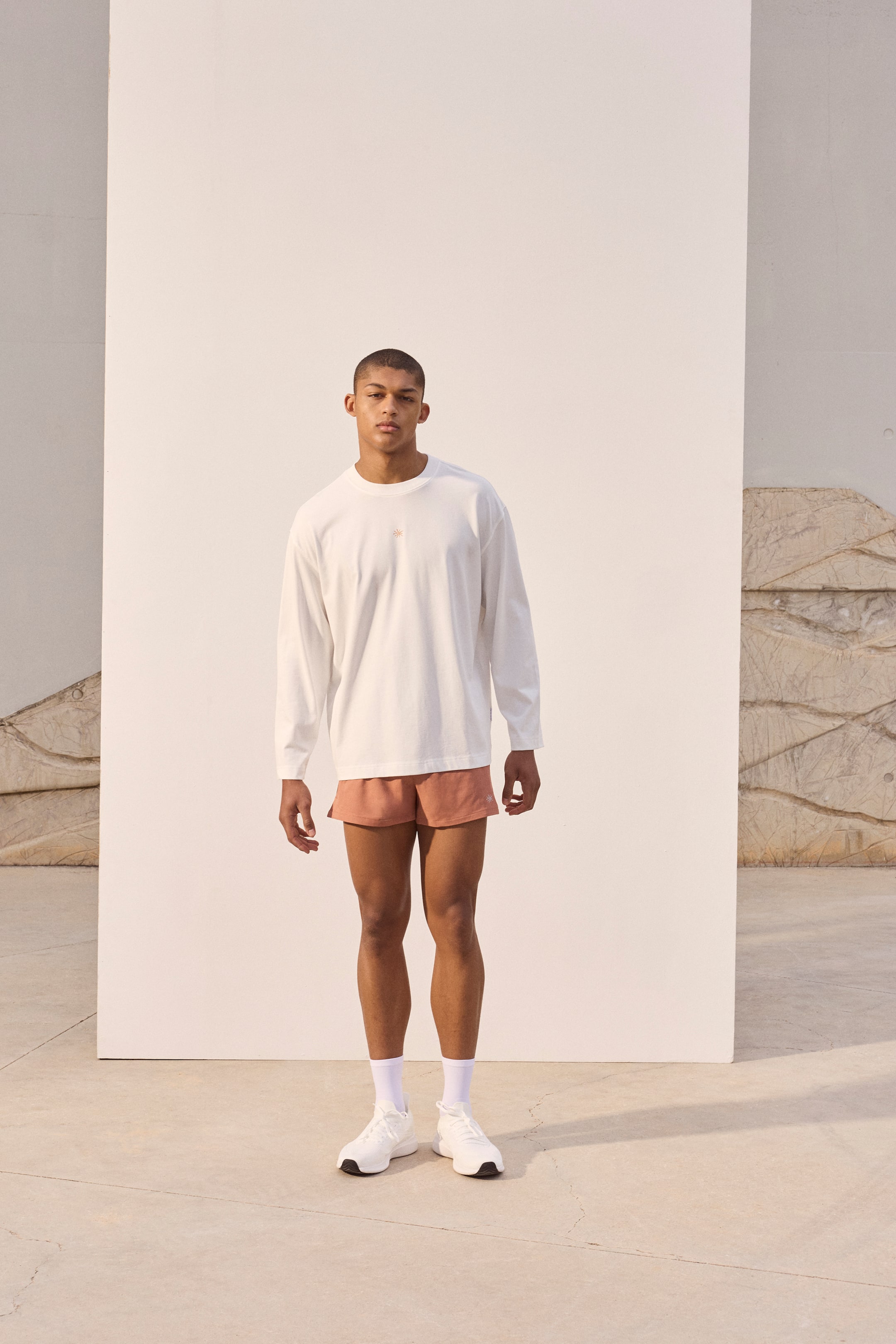 View larger image: "This white long-sleeve tee showcases a relaxed fit, crew neck, and long, loose sleeves. A small, light-coloured embroidered logo is subtly placed on the left chest."