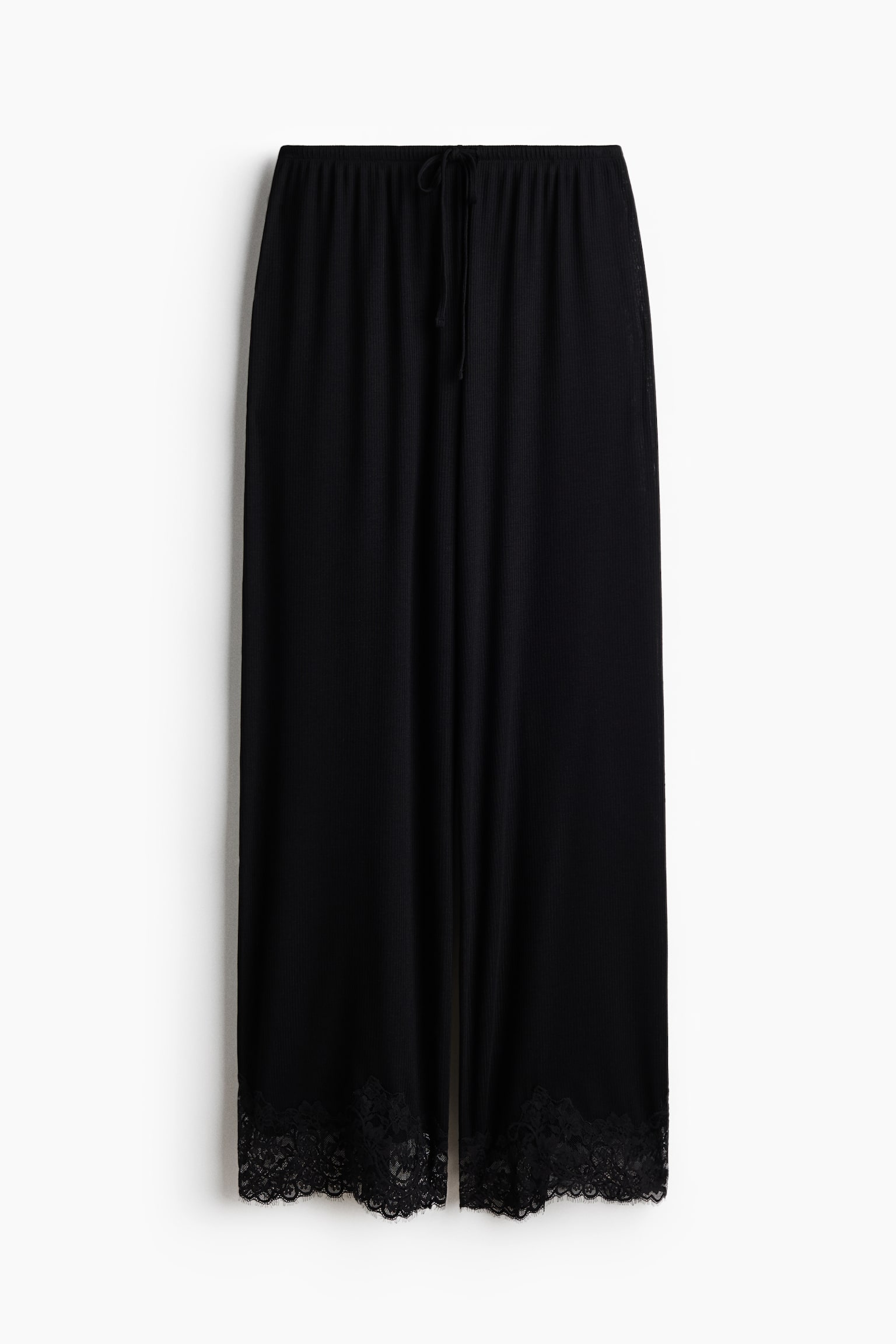 Pantalones negros de pierna ancha presentados desde el frente, con una textura acanalada y una cintura elástica con un cordón visible. Los dobladillos de las piernas muestran un ribete de encaje negro. - 1