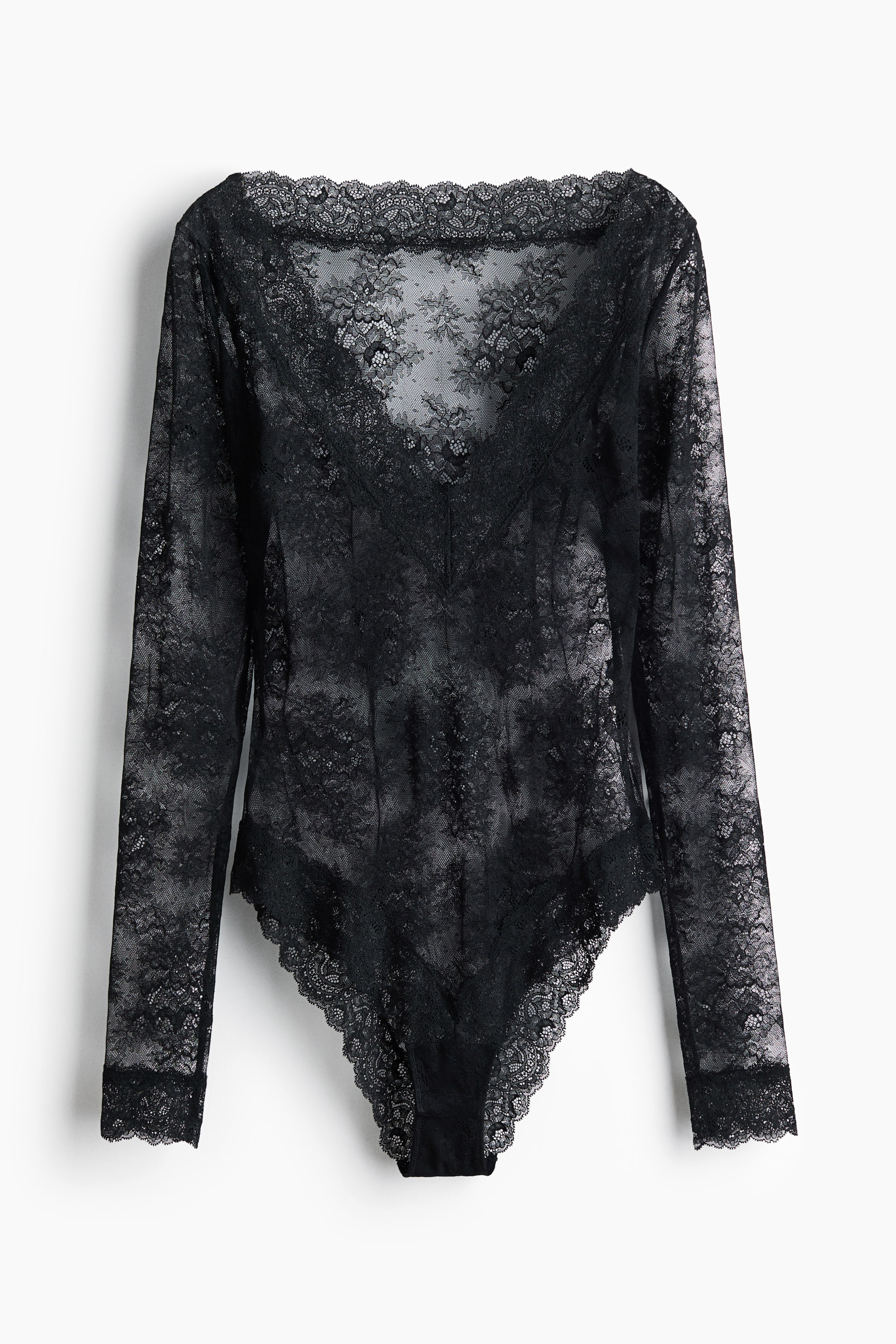 View larger image: A black lace bodysuit features a sheer floral lace pattern throughout, shown from the front. It is designed with a wide scalloped neckline, a deep V-neck overlay with scalloped trim, long sleeves, and scalloped lace leg openings.