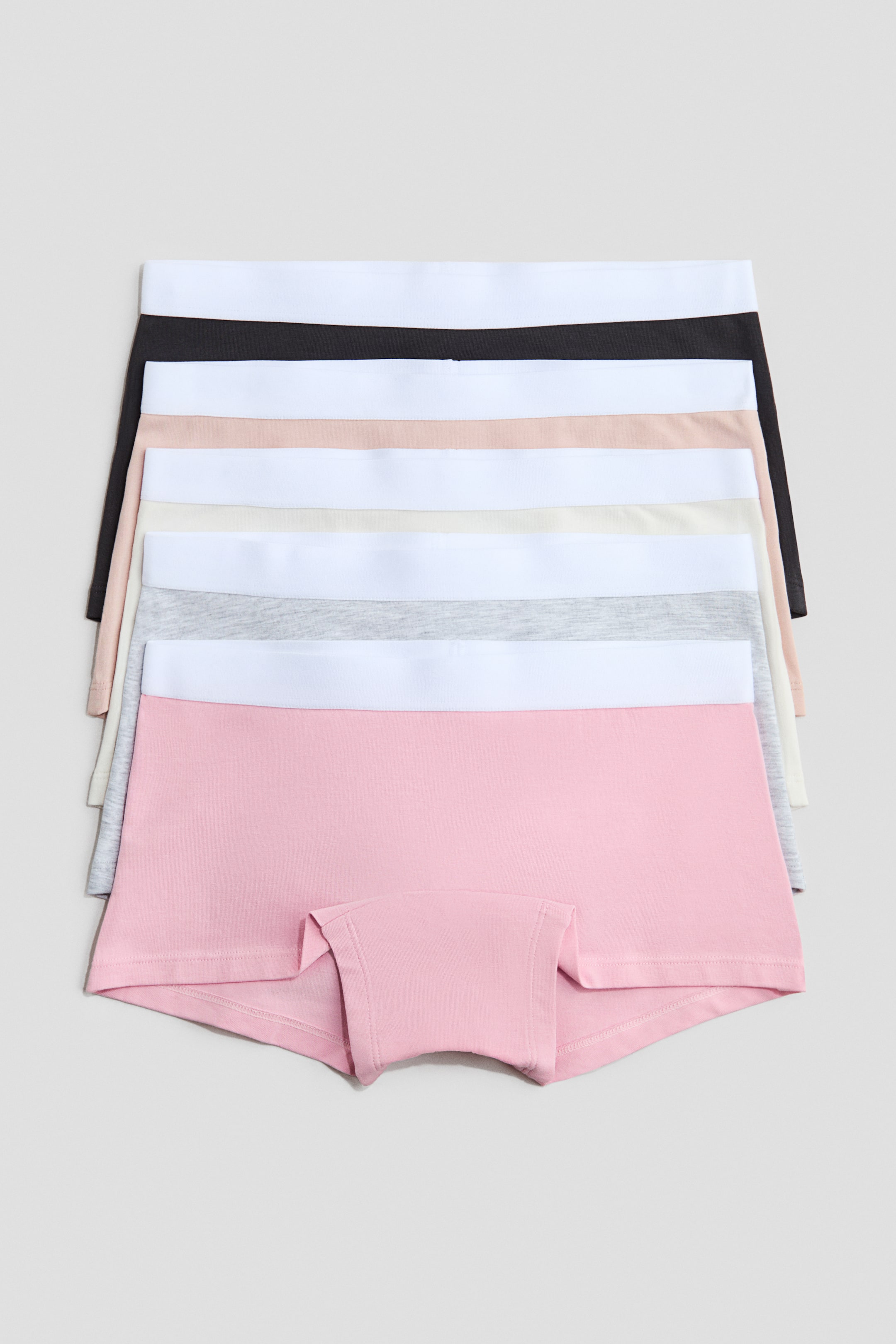 View larger image: A stack of cotton-jersey boxer briefs is on display, the front of a pink pair clearly showing its elasticated waist and lined crotch. Several other pairs in black, beige, white and grey are visible beneath, each featuring a white elasticated waist.
