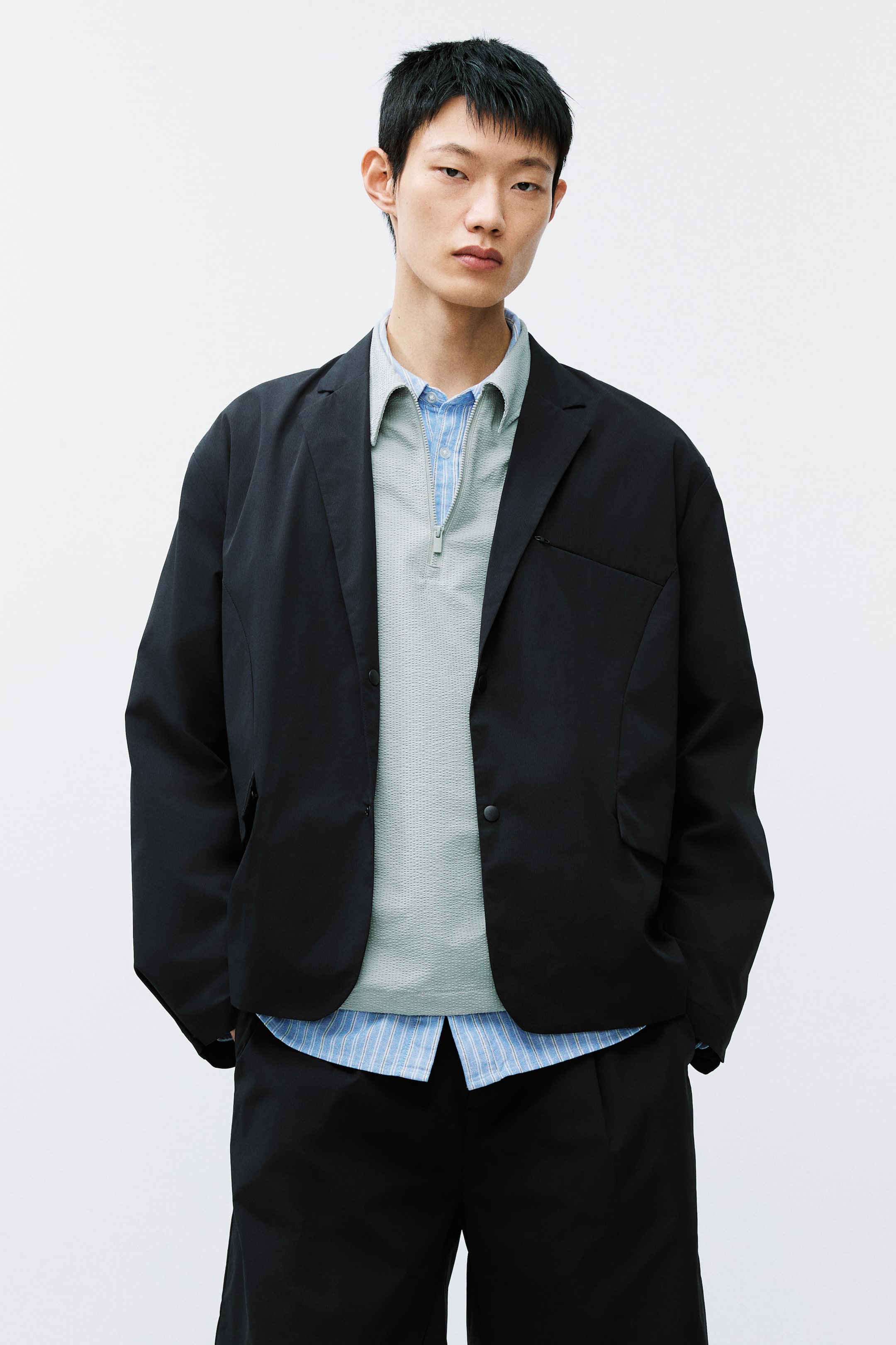 View larger image: Presenting a black single-breasted blazer from the front, showcasing a relaxed fit, notch lapels, a single button closure, and a left-side chest pocket.