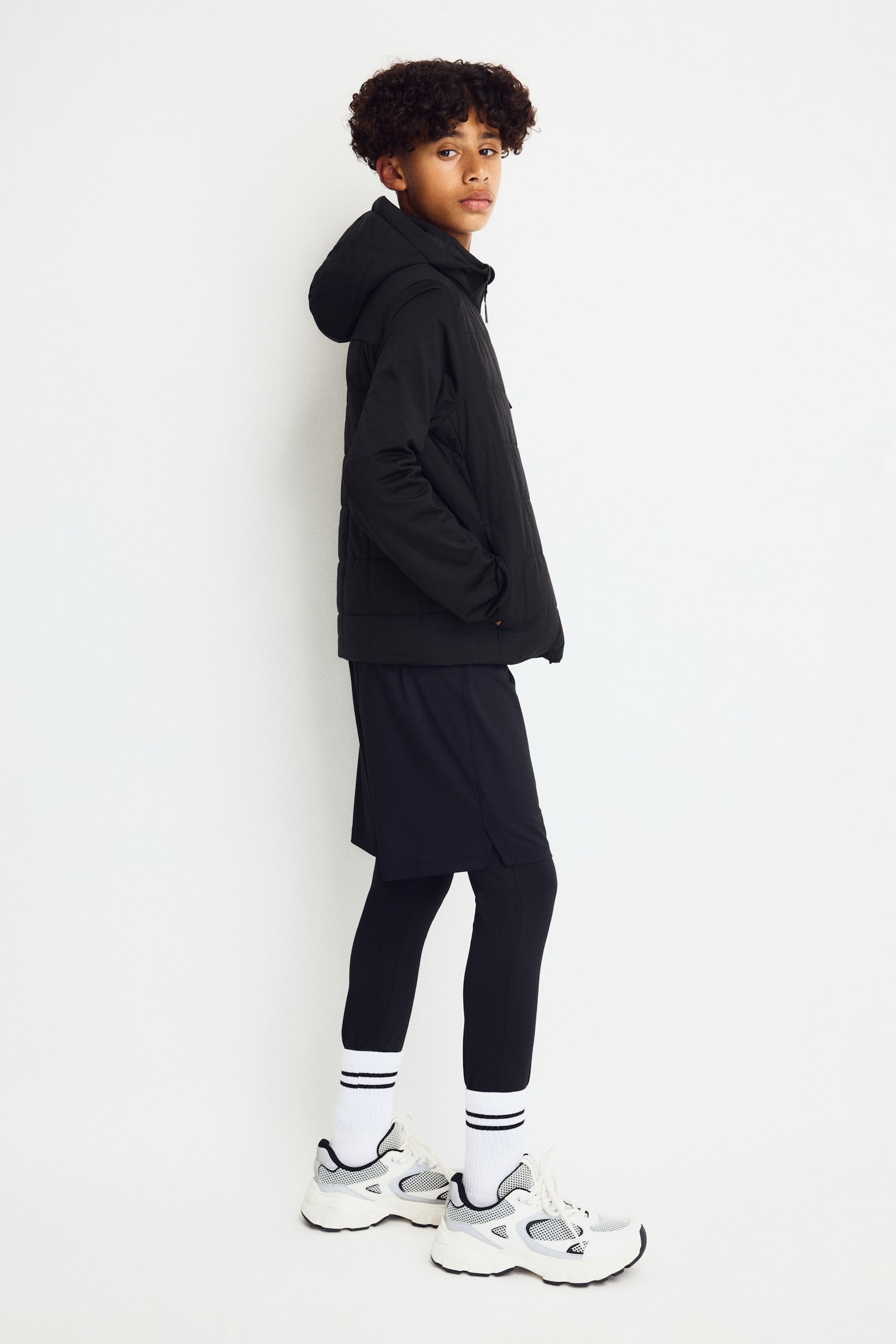 A black jacket is shown front-facing, featuring a square-quilted front body and hood with solid black sleeves. It is displaying a full-length central zipper, a vertical zippered pocket on the left chest, and the text "THERMOMOVE" positioned vertically on the lower right sleeve. - 1
