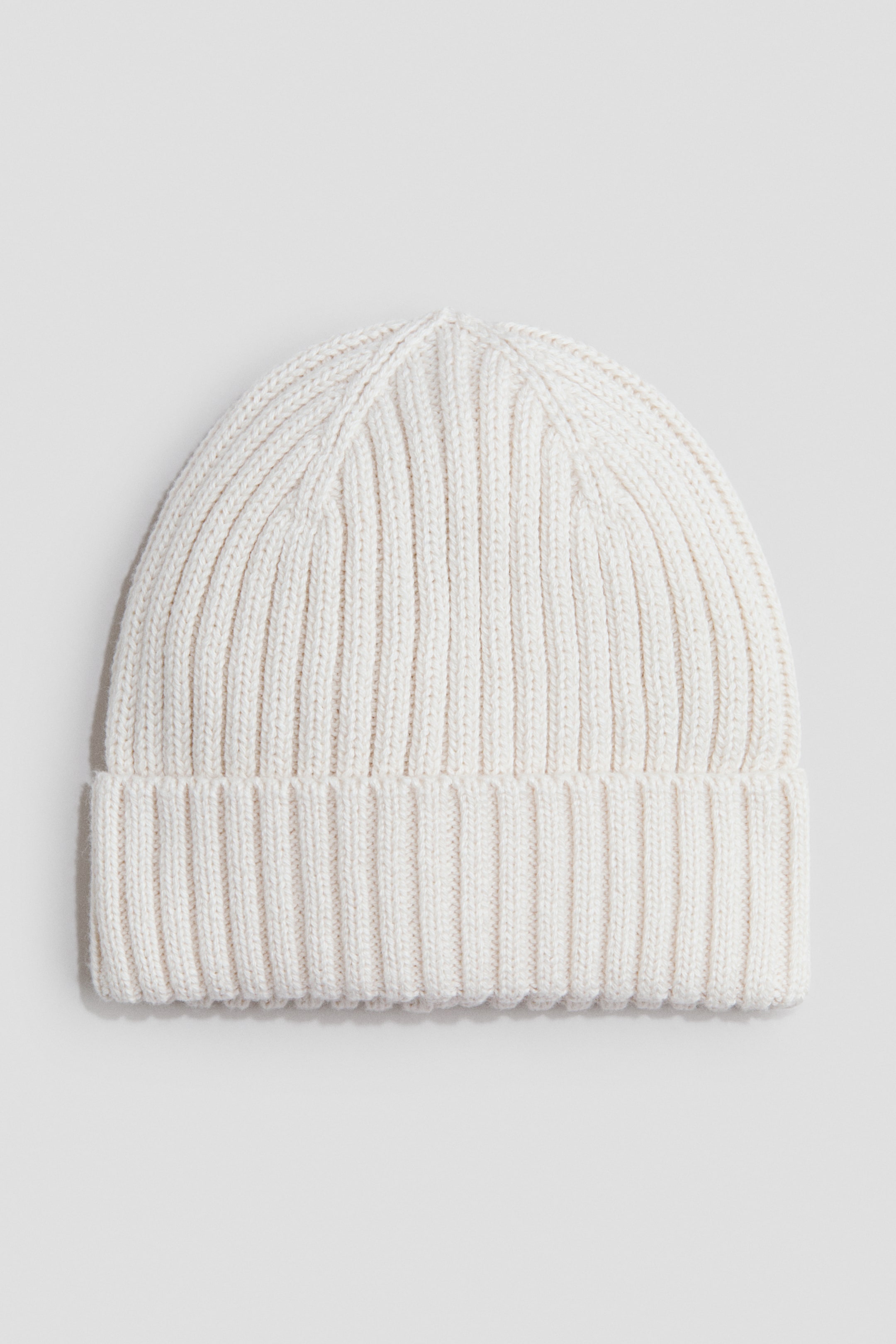 View larger image: A cream knit beanie menampilkan corak rajutan berusuk menegak di seluruhnya, dengan bahagian tepi bawahnya membentuk brim lipatan lebar berlapis dua.