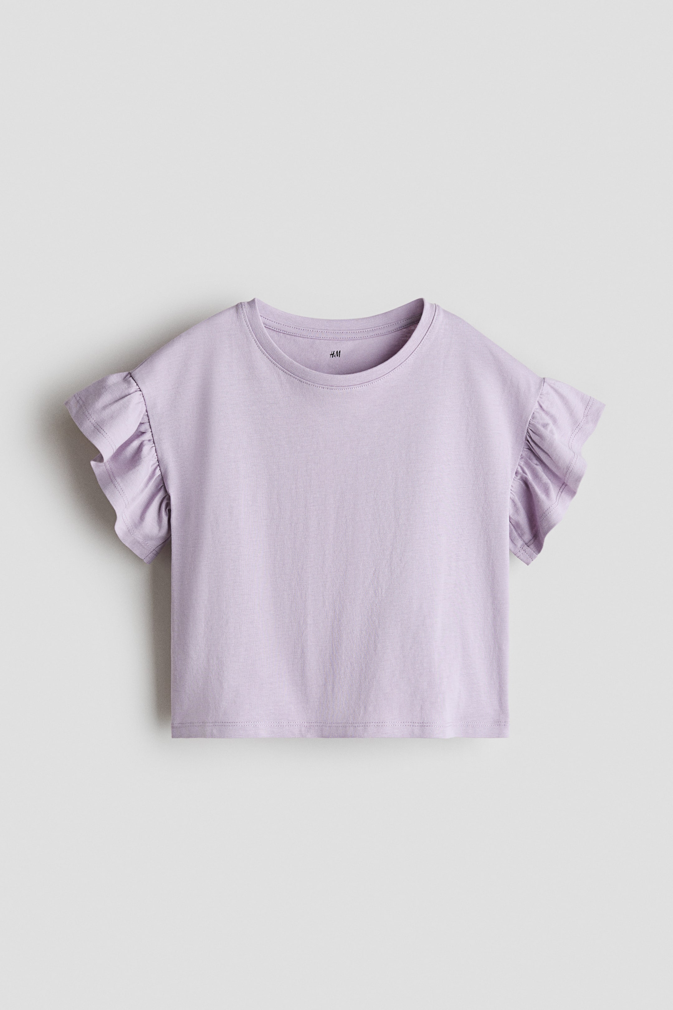 Grotere afbeelding bekijken: Een vooraanzicht van een lichtpaarse, boxy top gemaakt van zachte katoenen jersey. Het heeft een ronde, geribbelde halslijn, laag ingezette schouders en vlindermouwen.