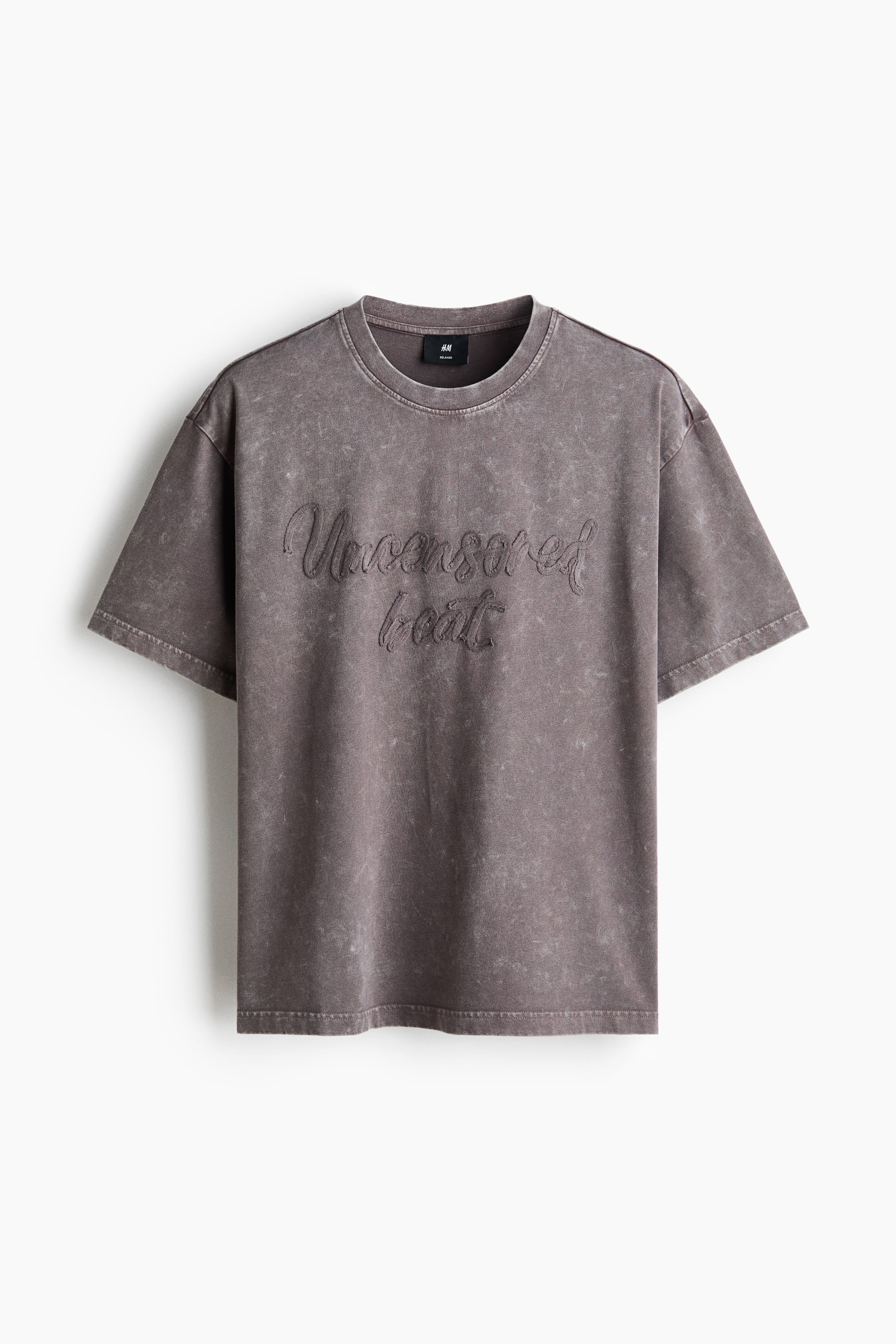 View larger image: A charcoal grey t-shirt featuring a washed-out effect and short sleeves, offering a relaxed fit. It showcases a crew neck with the embossed text "Uncensored beat" in a script font on the front.