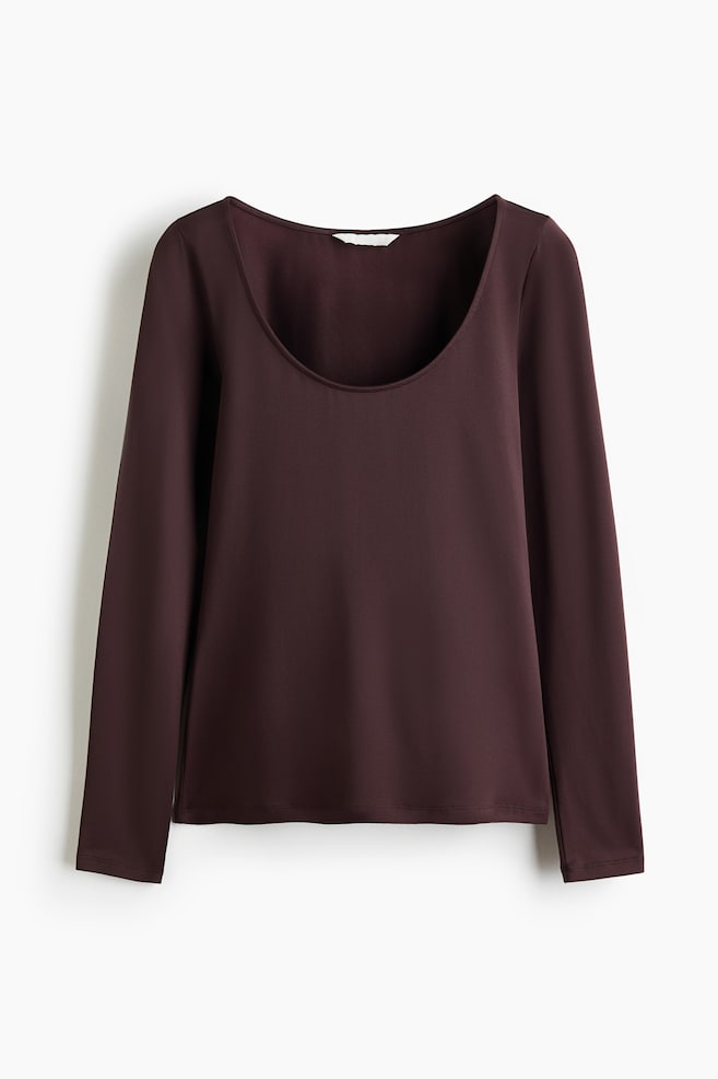 A dark plum long-sleeved top is lying flat, displaying a wide scoop neck and a straight hem. - 1