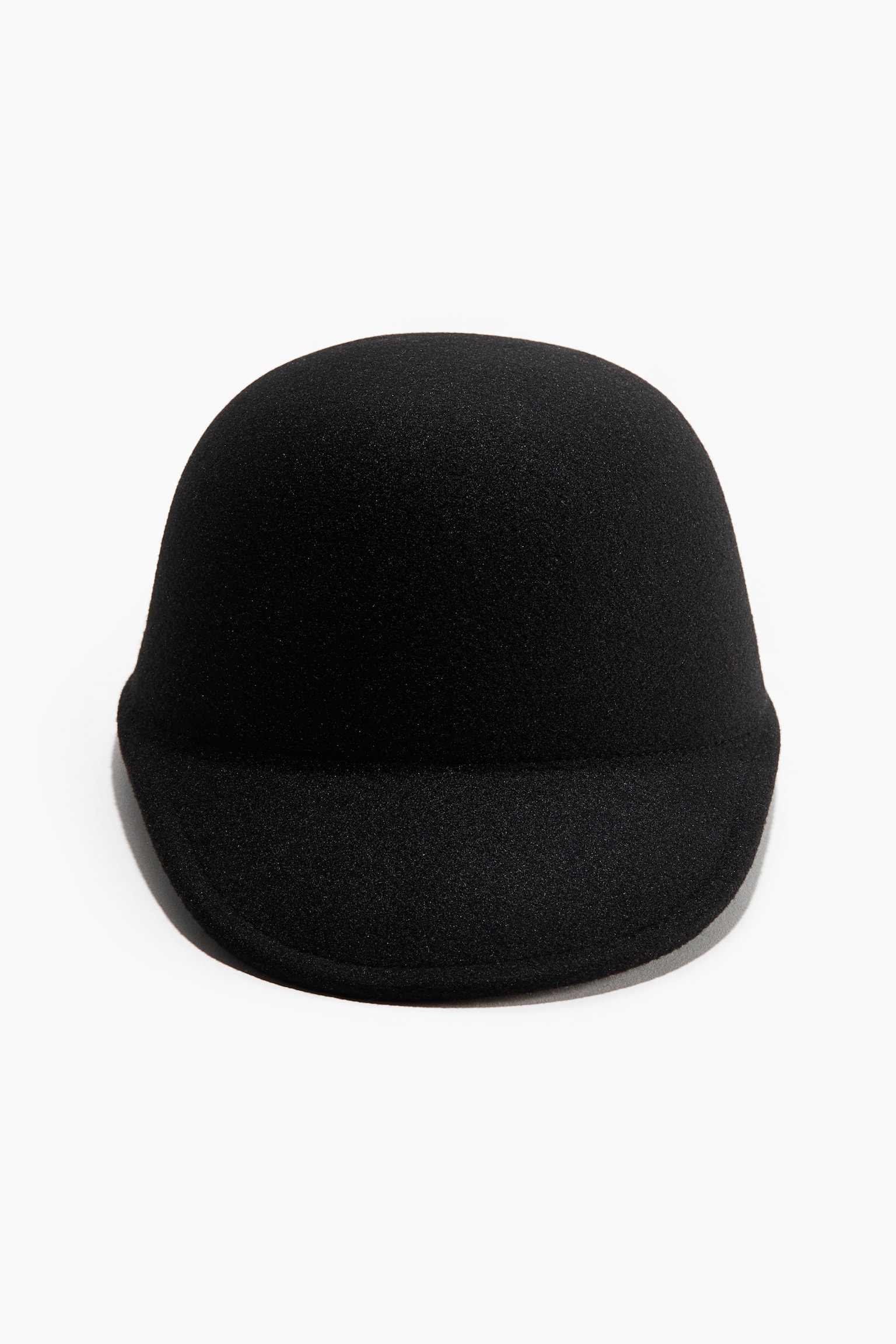 La casquette noire présente une calotte arrondie et subtilement texturée, ainsi qu'une courte visière arrondie orientée vers l'avant. - 1