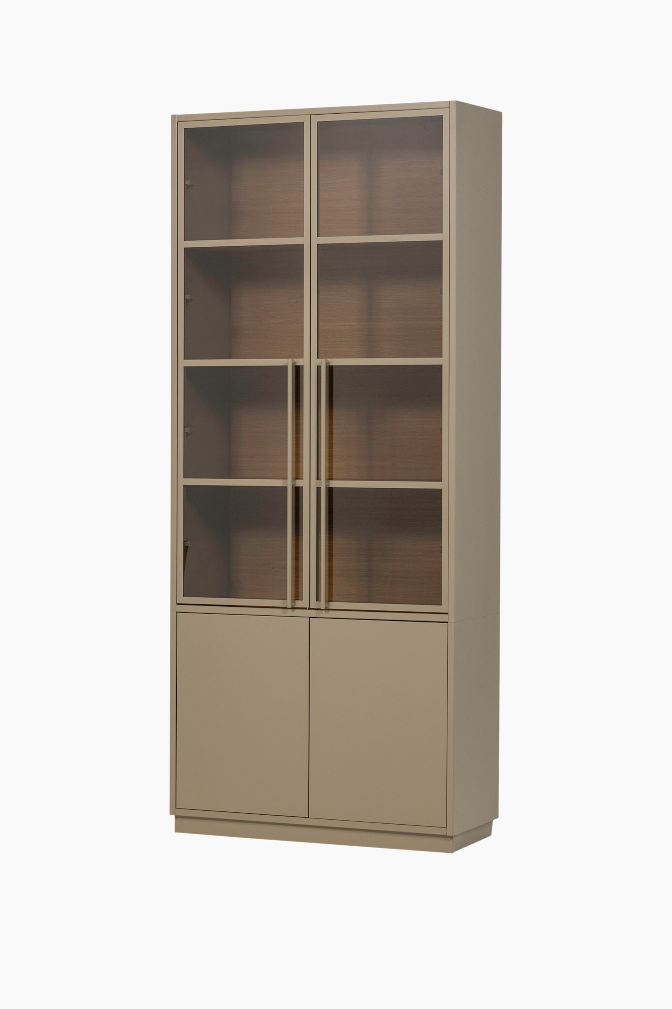 Agrandir l'image: Un grand cabinet rectangulaire taupe est légèrement incliné vers la droite. Sa partie supérieure présente deux portes vitrées, chacune divisée en quatre carreaux transparents et dotée d'une poignée verticale, révélant des étagères à grain de bois à l'intérieur. En dessous, deux portes de cabinet solides taupe forment la partie inférieure, et le cabinet repose sur une base encastrée.