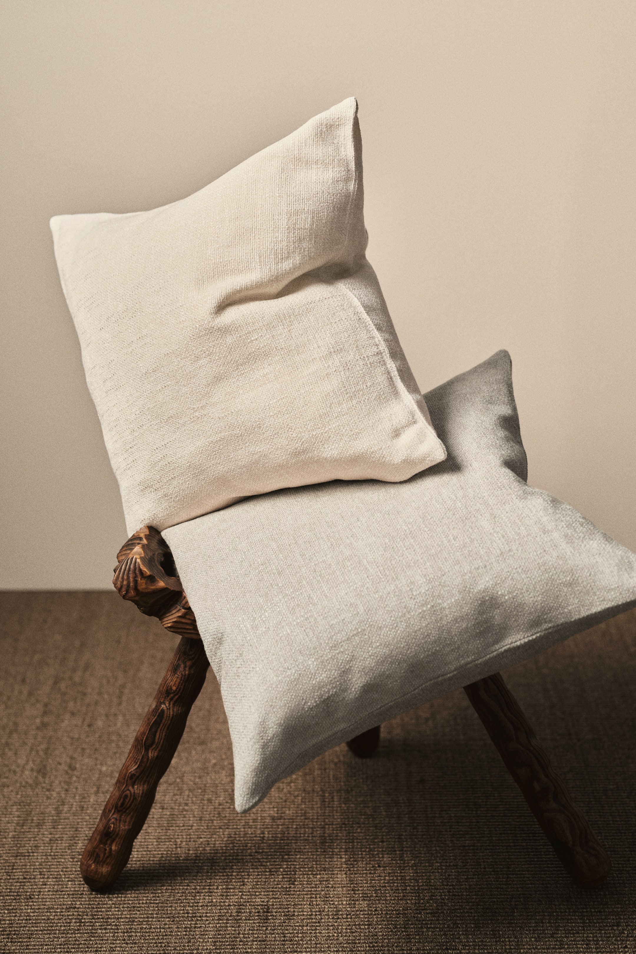 View larger image: Two pillow covers are displayed, one in light beige and the other in light gray, both showcasing a soft chenille weave. Each cover is crafted with a zipper running along one side.