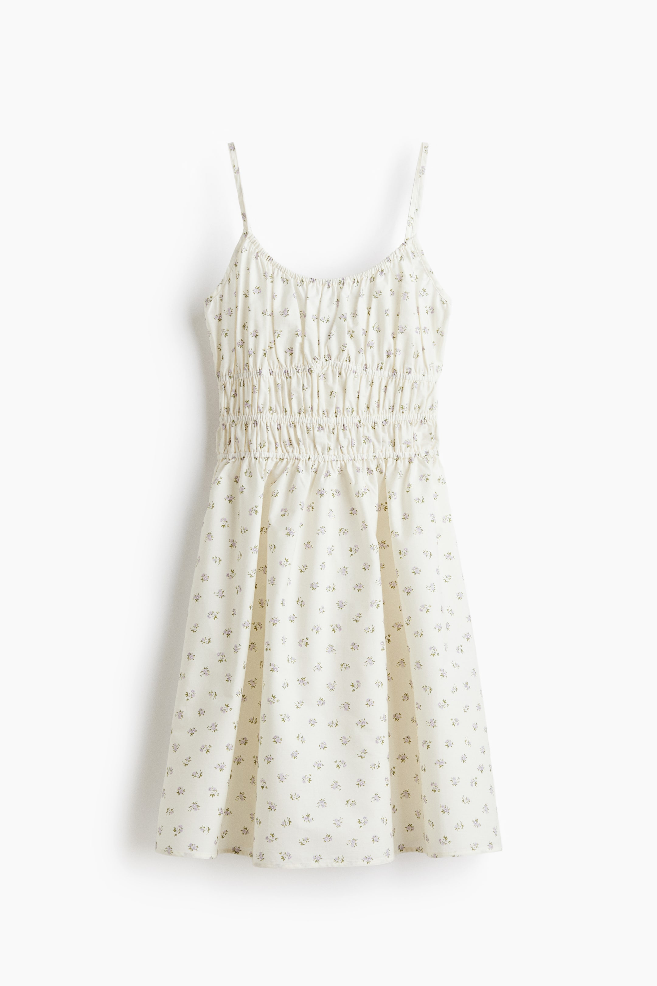 View larger image: "A short dress is showcased from the front, crafted from a white fabric adorned with a delicate floral print. It boasts a deep, round neckline with covered elastication, slender shoulder straps, and smocking at the waist, culminating in a flared skirt."