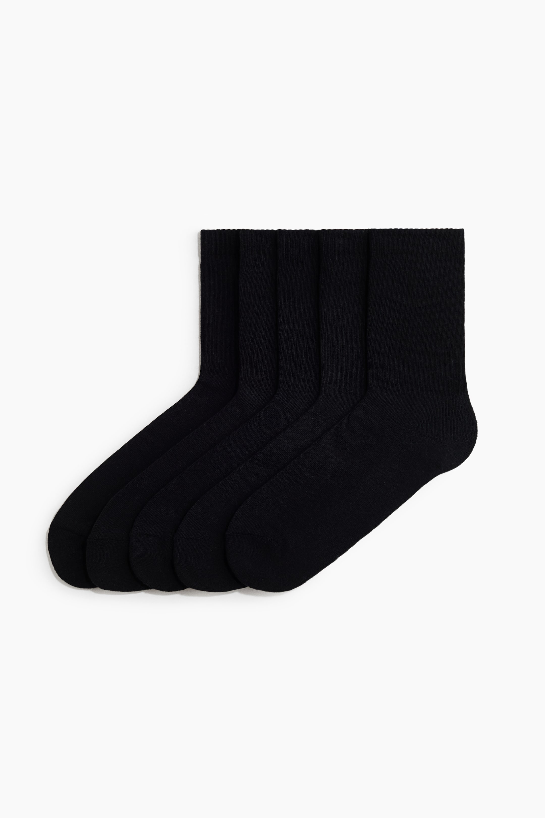 Agrandir l'image: Cinq chaussettes montantes noires unies sont posées à plat et se chevauchent en rangée diagonale, orientées vers la droite. Les chaussettes présentent une texture finement côtelée sur la tige et un tricot lisse sur le pied.
