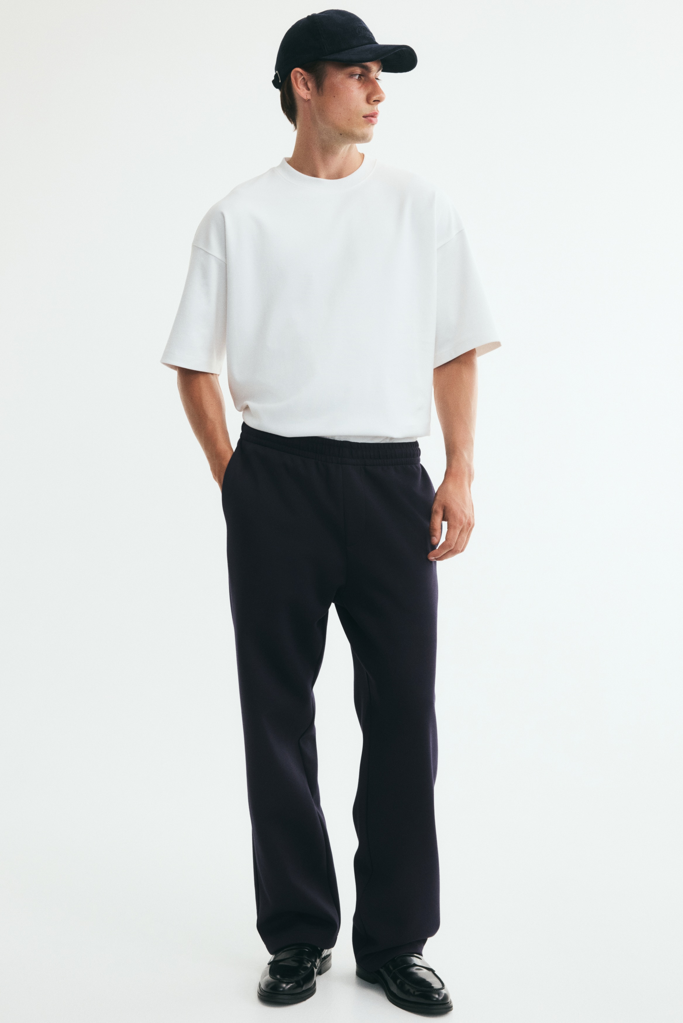 Φόρμα σε βαρύ interlock jersey με ελαστική μέση με σούρες και ψεύτικο φερμουάρ. Το μπροστινό μέρος διαθέτει διακριτικές πλαϊνές τσέπες, ίσια πόδια και χαλαρή εφαρμογή.