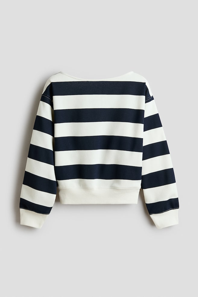 A long-sleeved sweatshirt featuring bold horizontal navy and off-white stripes is being shown from the back. It is displaying a wide neckline, dropped shoulders, and solid off-white ribbed cuffs and hem. - 1