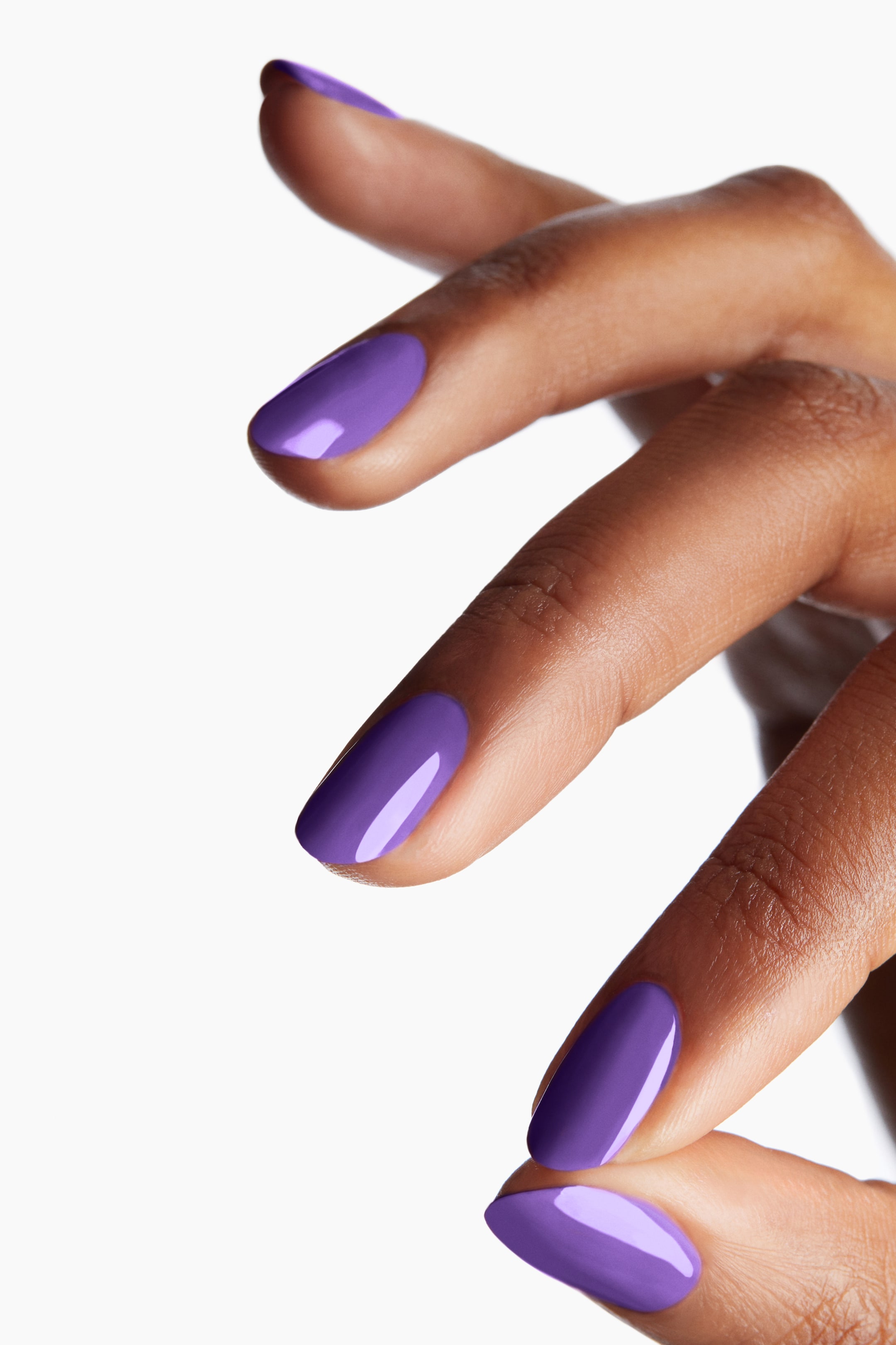 View larger image: The nail polish showcases a lively, glossy purple sheen on several oval-shaped fingernails.